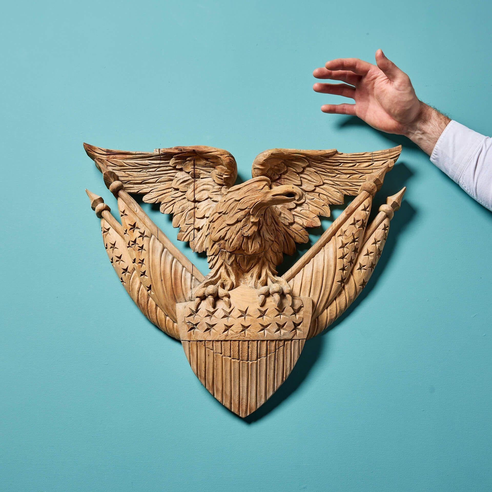 Aigle américain en pin de la fin du XIXe siècle, sculpté à la main en très profond relief au-dessus d'un bouclier et de quatre drapeaux marqués d'étoiles et de rayures.

Cette sculpture superbement réalisée respire la puissance et l'influence.