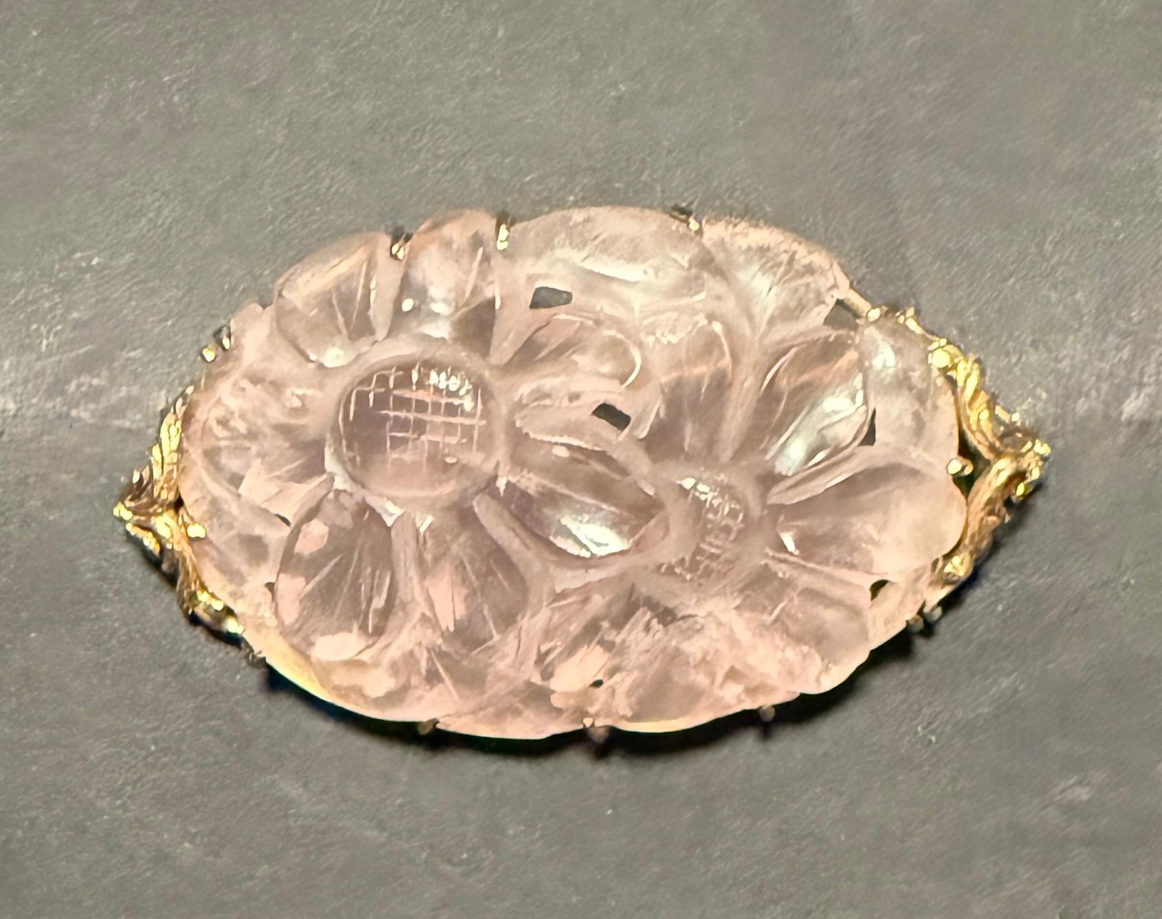 Fine quality hand carved oval rose quartz pin brooch set in a 14K yellow gold frame. This is a vintage piece of estate jewelry circa 1910. The frame is an elegant thin oval setting with stylized fleur-de-lis at each end.
Marked and tested 14K.