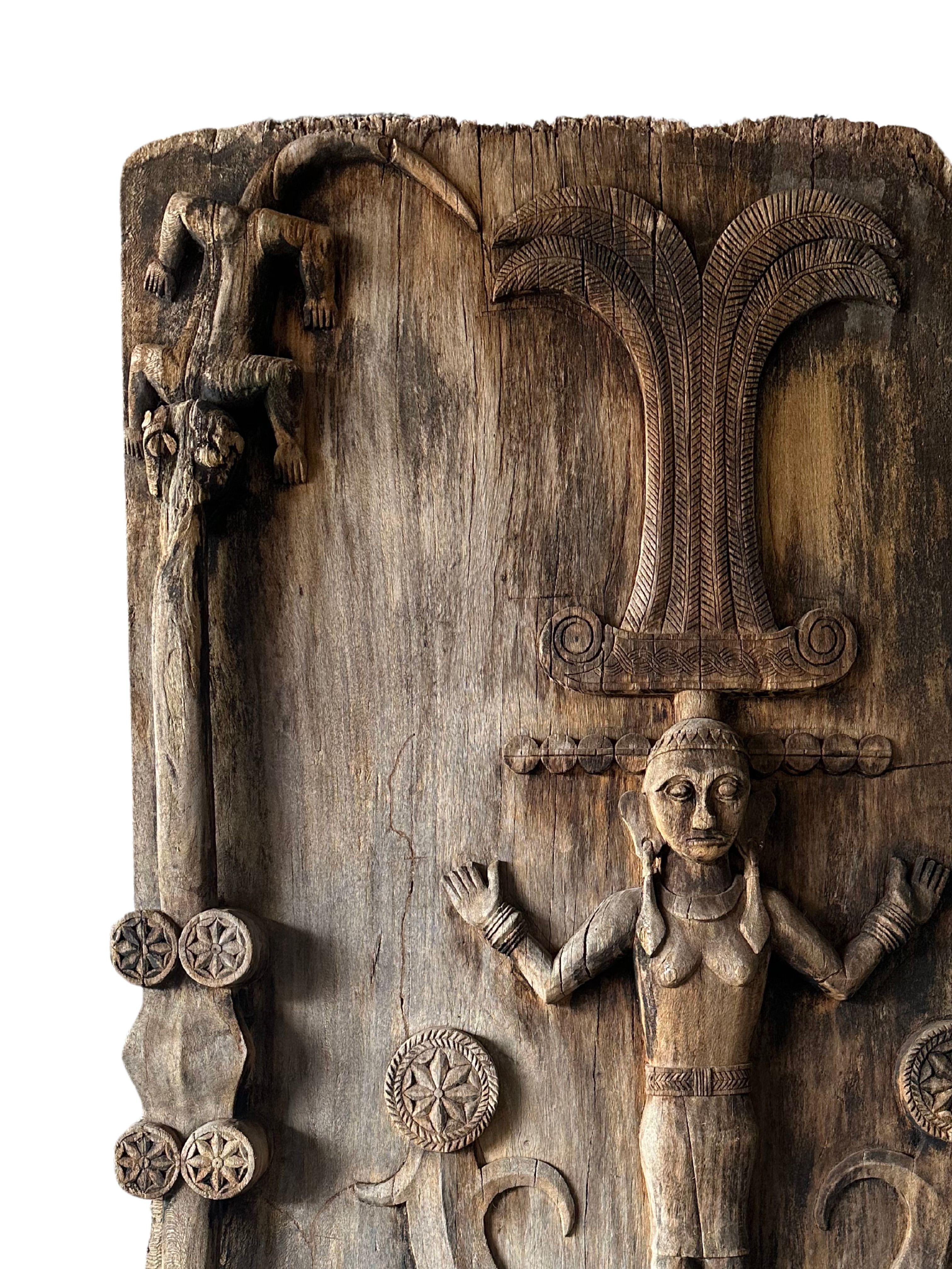 Esta excepcional Puerta Tribal Antigua de Madera Tallada procede del rico patrimonio cultural de la isla de Nias, Indonesia, y antaño adornaba los umbrales sagrados de la realeza tribal. La puerta es una exquisita representación de la artesanía y