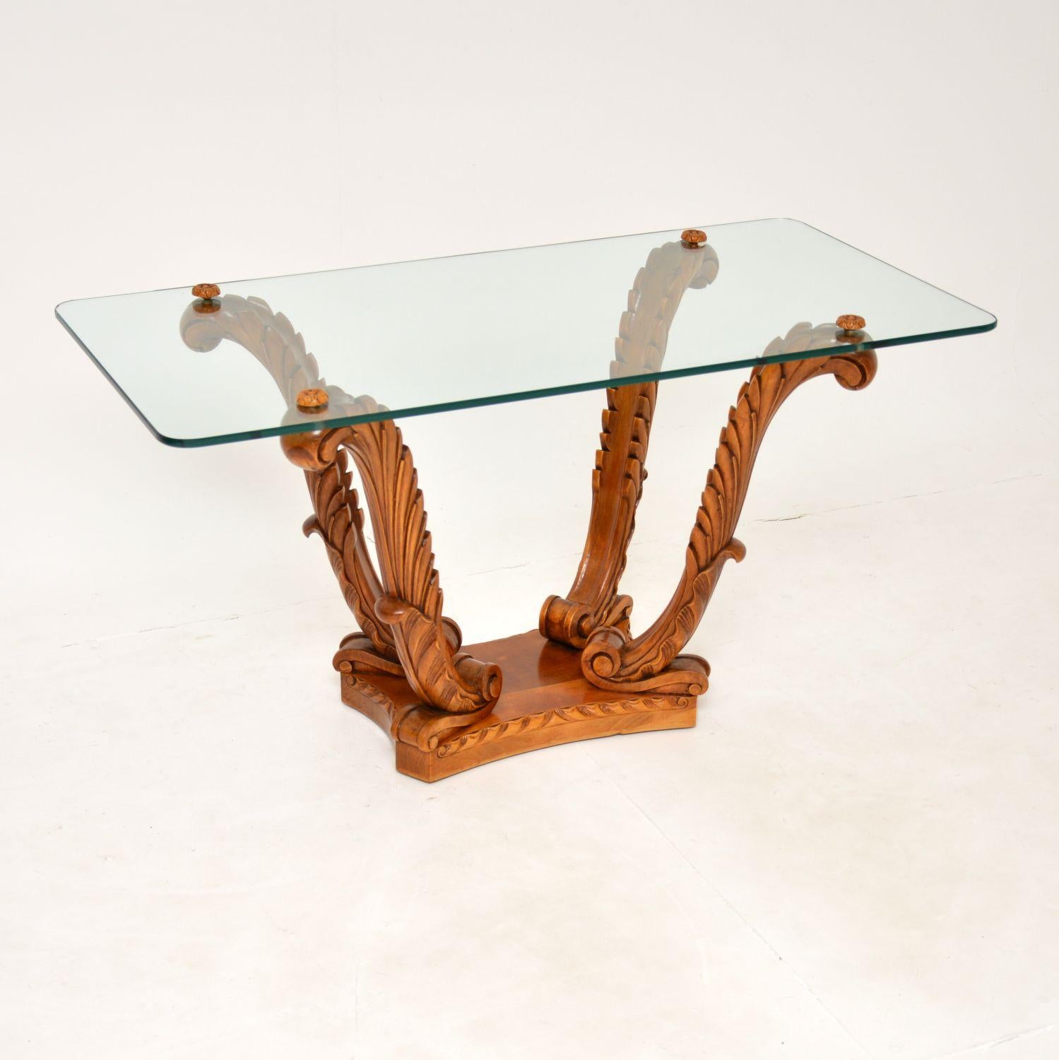 An absolutely stunning antique glass top coffee table, beautifully carved from solid satin wood. This was made in England by Hille, it dates from the 1920-1930’s.

The quality is exceptional, with profuse and crisp carving all over the base. The