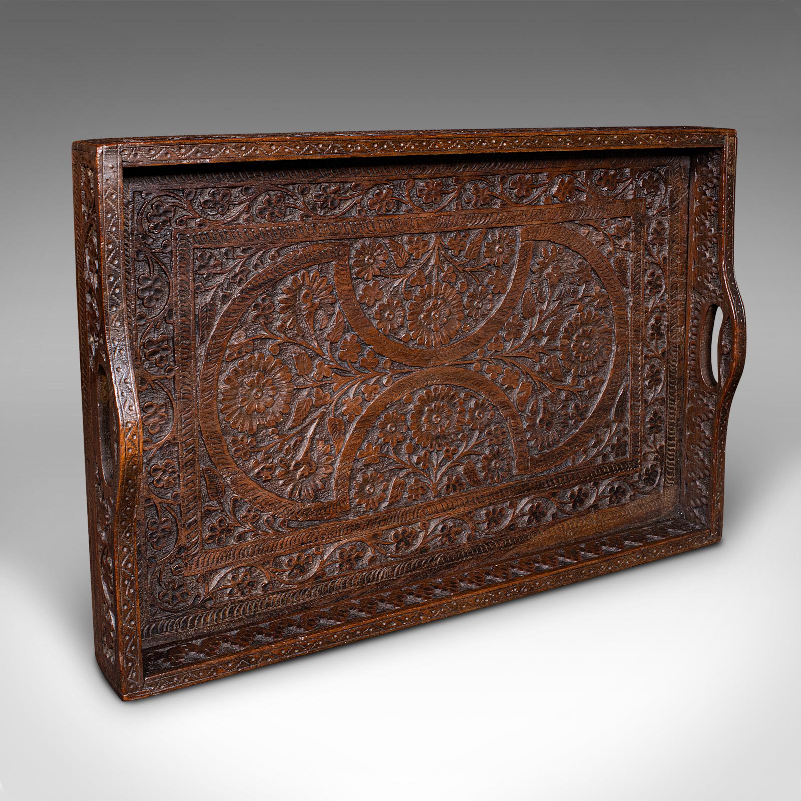 This is an antique carved serving tray. An Anglo-Indian, teak afternoon tea or cocktail platter, with delightful colonial taste, dating to the late Victorian period, circa 1900. A fine display of craftsmanship with rich colour and ornate