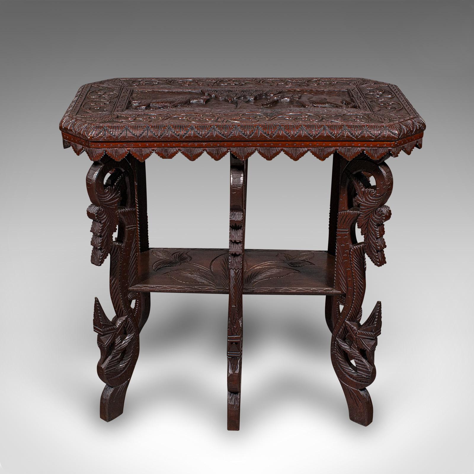This is an antique carved side table. An Indian, teak lamp or tray table, dating to the late Victorian period, circa 1900.

Fascinating carved appearance with a distinctive form
Displays a desirable aged patina and in good order
Teak stocks present
