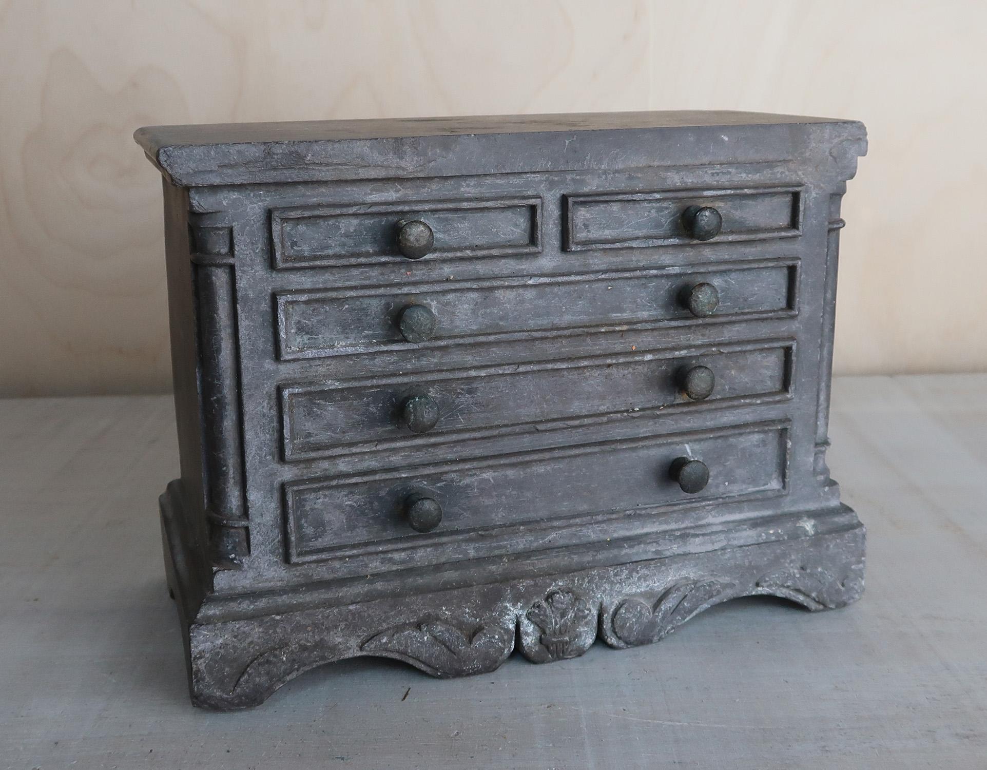 Un'affascinante cassettiera in miniatura realizzata in ardesia intagliata

Con cassetti a manichino e dettagli in piume di Wales and Wales.

Cassapanche in miniatura, bureau e simili pezzi d'arte popolare venivano intagliati dai cavatori nel Wales