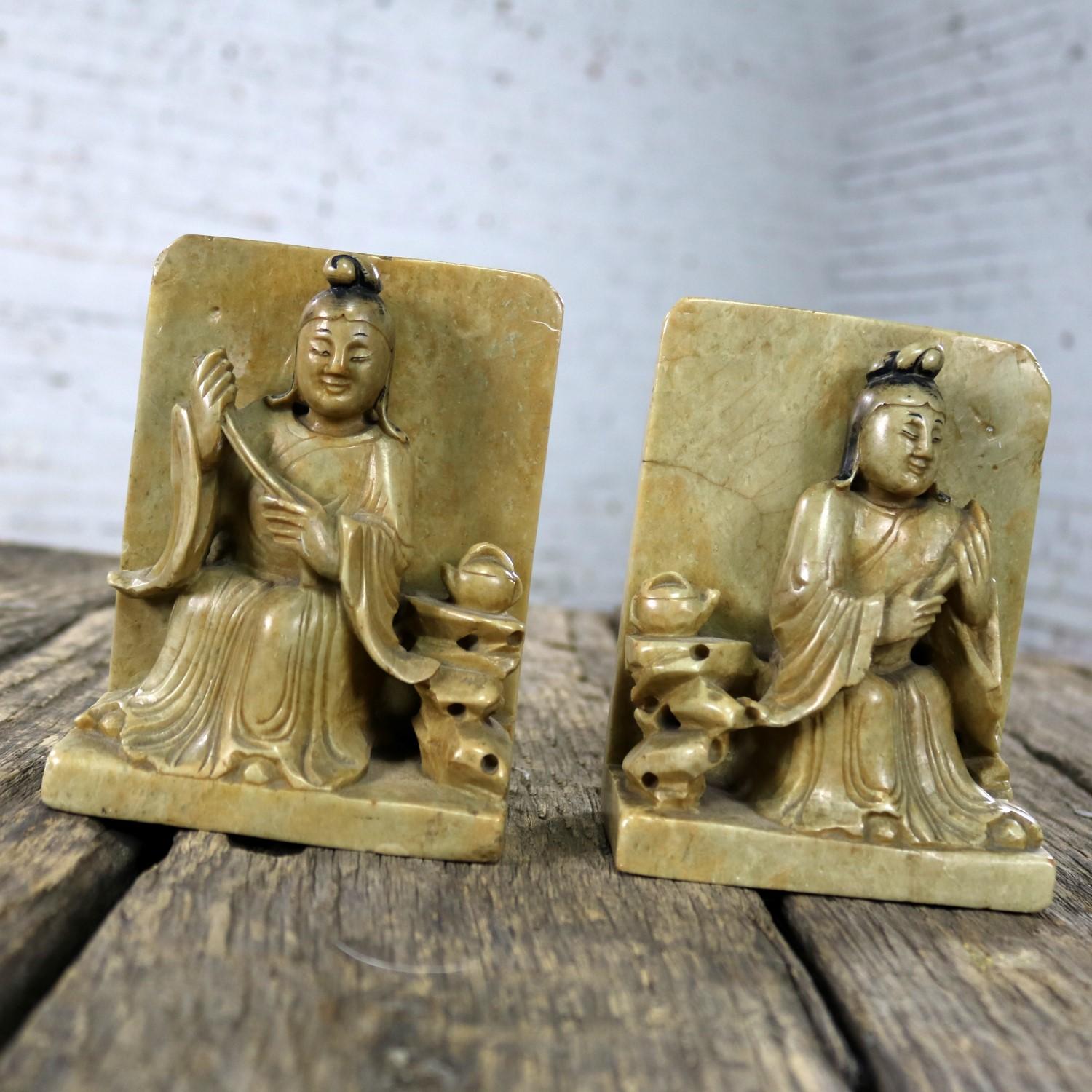 Handsome and intricately carved Chinese soapstone bookends depicting Asian seated figures and teapot detail. They are in wonderful antique condition. They do have nicks and chipping and veining which only enhances their lovely patina, circa early