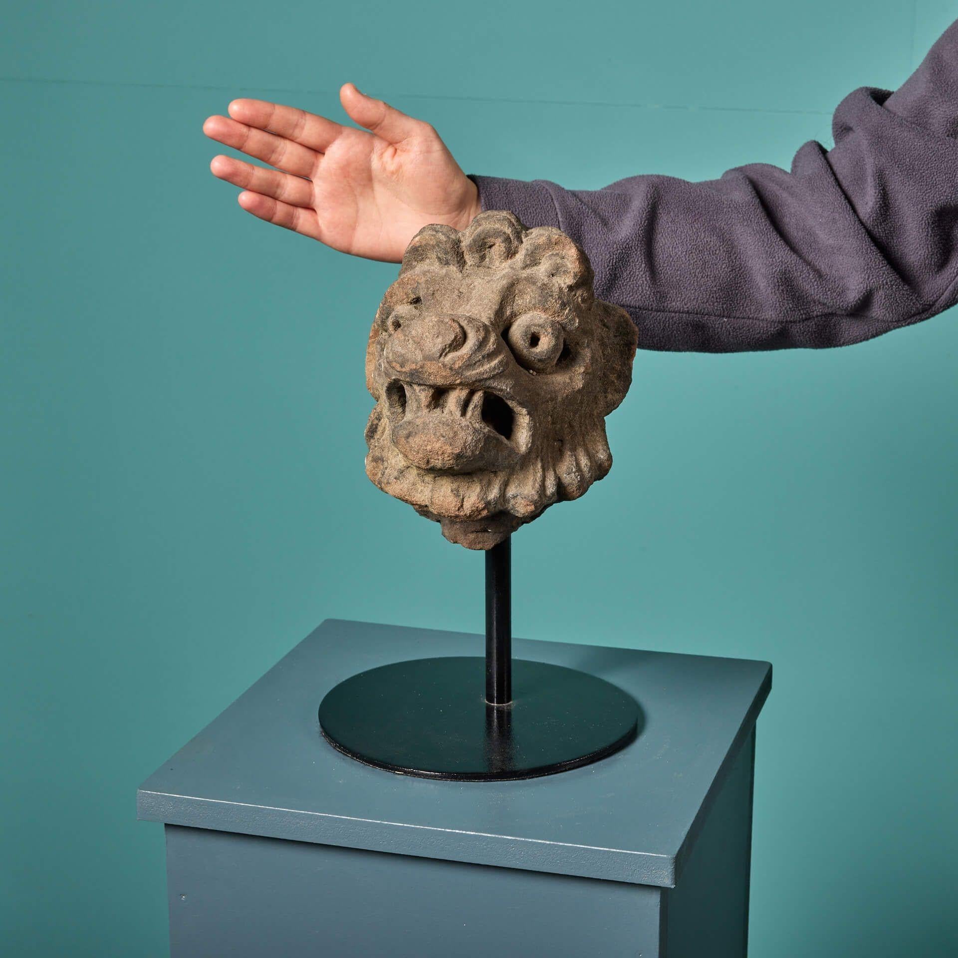 An antique carved sandstone head of a lion, mounted to a custom steel display stand. This interesting looking lion dates back hundreds of years to the Stuart period in the 1600s - a time when lion-baiting was a a new and popular source of