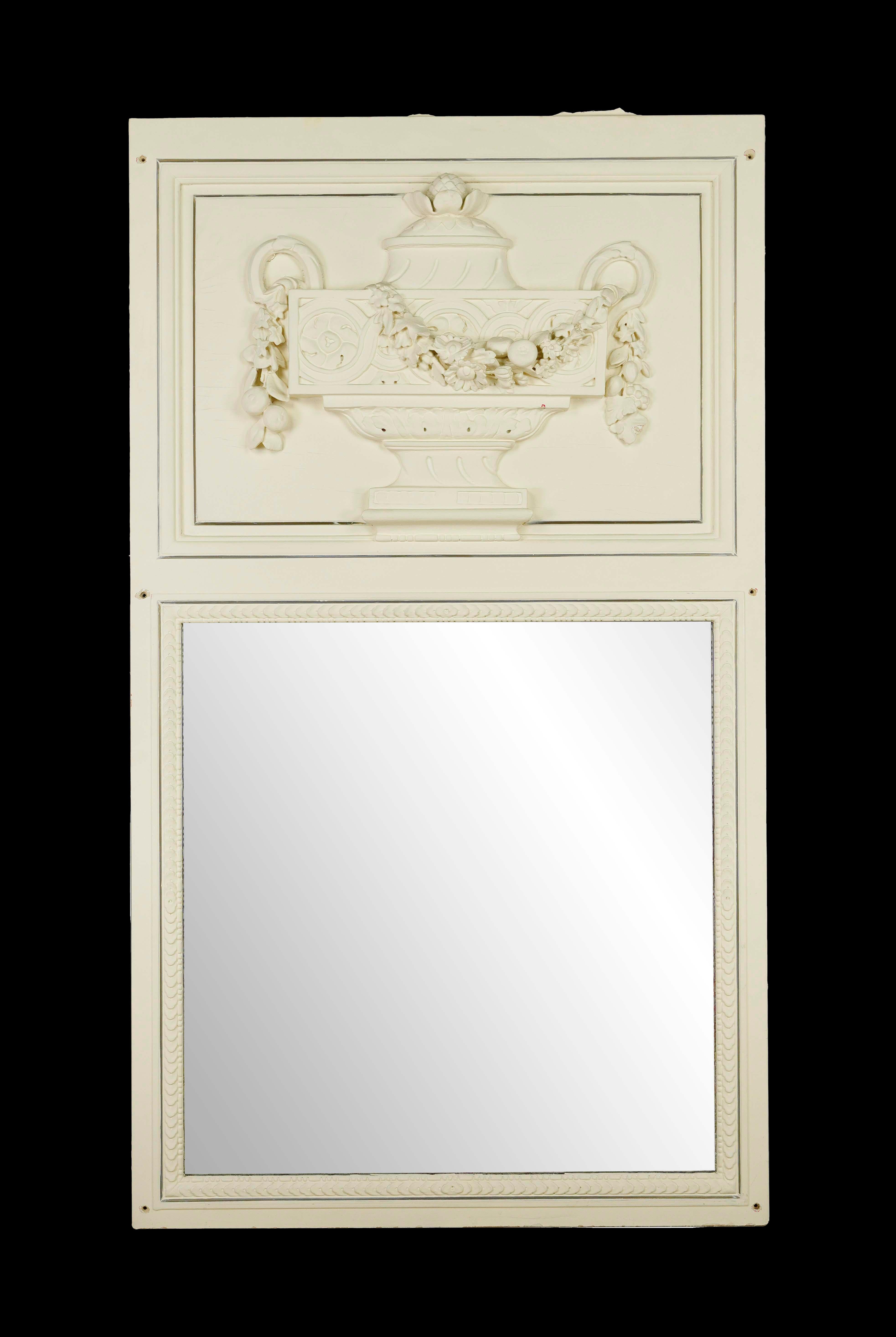 Fabriqué avec soin, ce miroir présente un cadre en bois blanc orné d'un magnifique motif d'urne sculpté. La bordure en laiton qui entoure le plâtre ajoute une touche de sophistication, soulignant les détails complexes. En très bon état, ce miroir