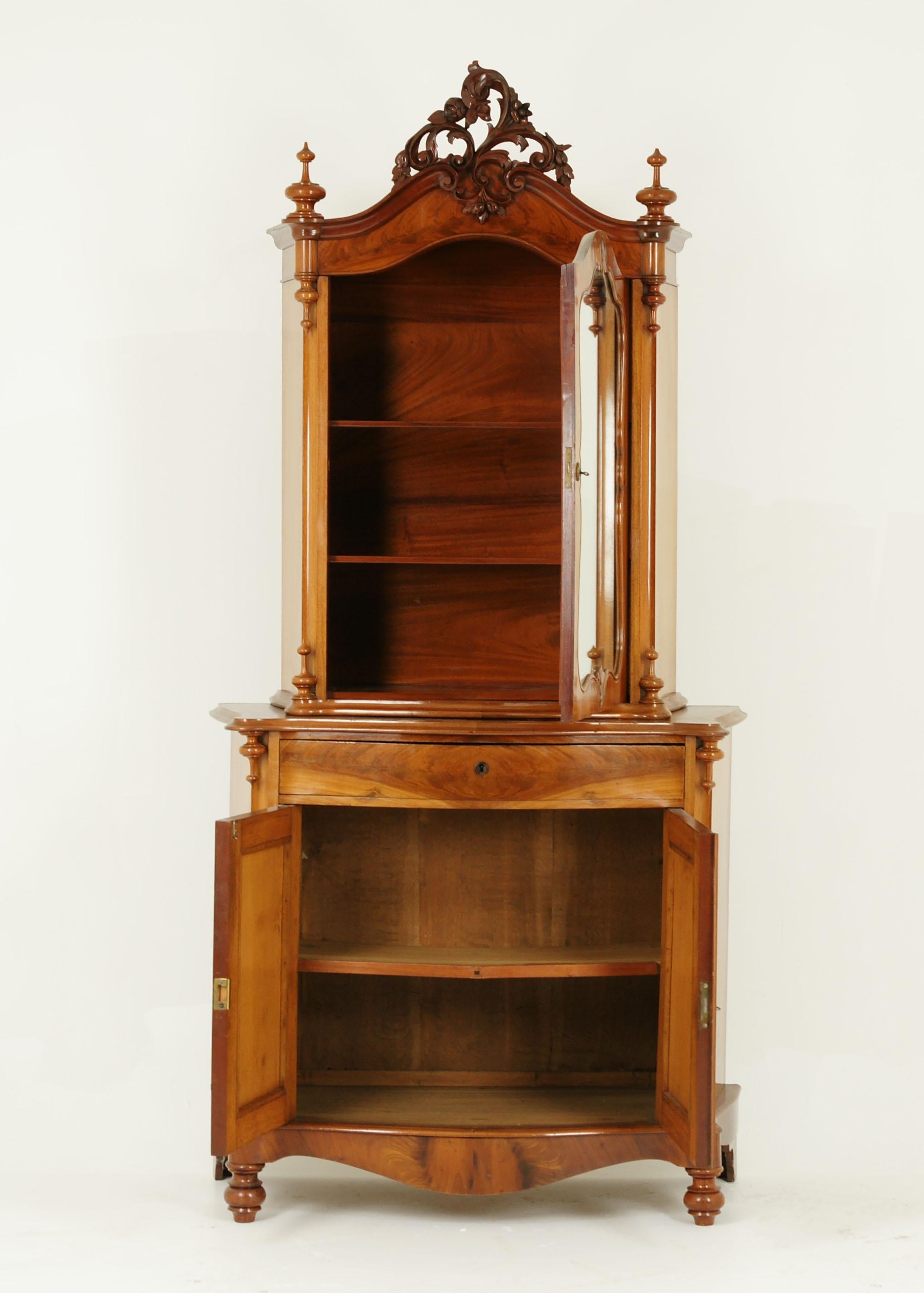 Antique carved vitrine, carved cabinet, walnut, Austria 1880, antique furniture

Austria 1880
Solid walnut with original finish
Carved pierced pediment to the top
Pair finials below
Elaborate shaped mirror door
Opens to reveal pair of solid