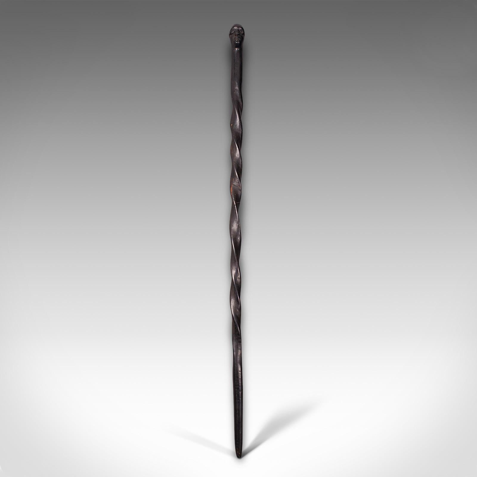 This is an antique carved walking cane. An African, ebony tribal stick with figural male mask, dating to the late Victorian period, circa 1900.

Wonderful tribal cane with pleasing detail
Displays a desirable aged patina throughout
Ebony cane