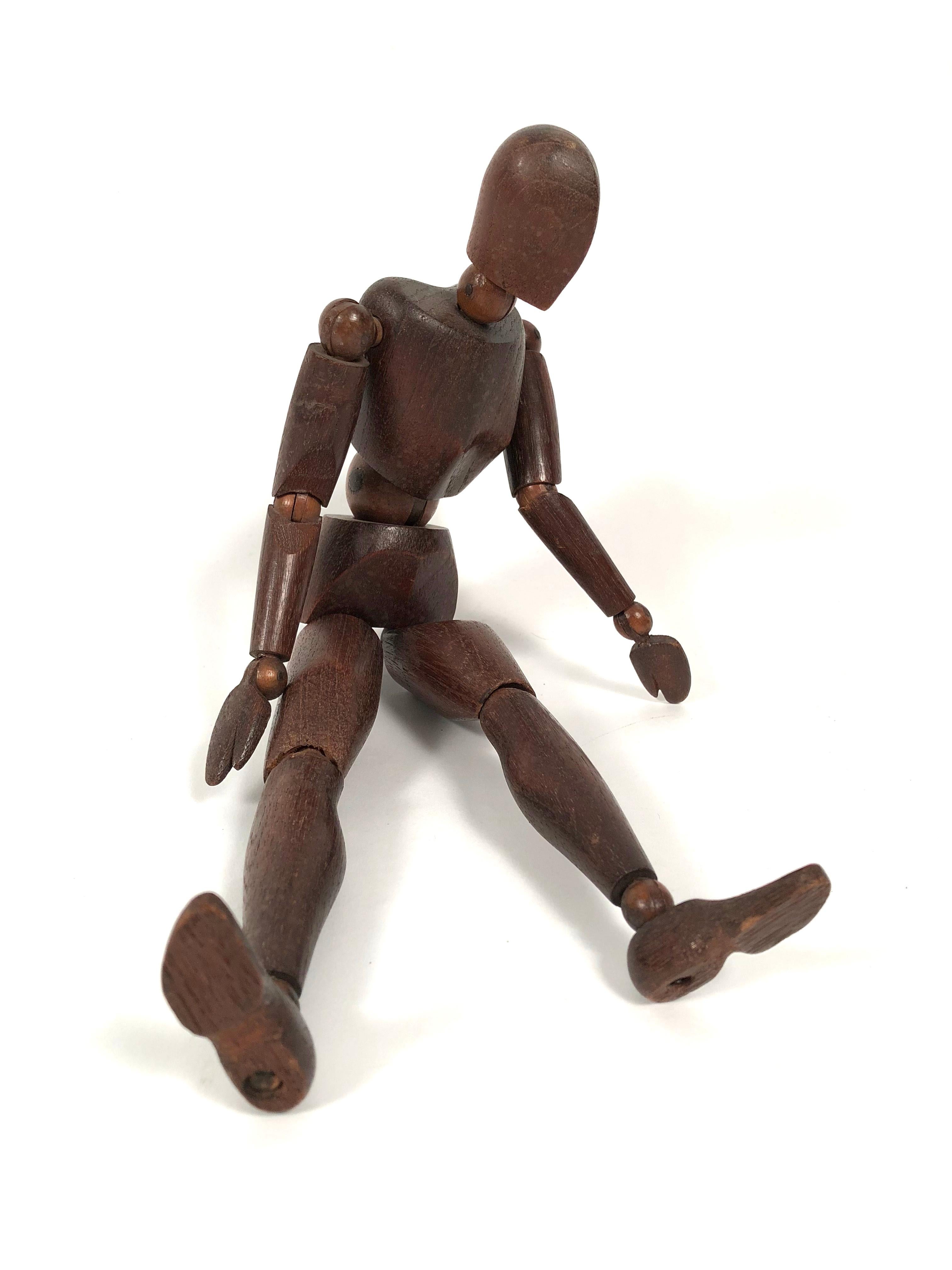 An antique carved walnut articulated artist's figure model, with 14 moveable ball joints and stylized hands and feet. Beautiful as sculpture on a table or book shelf.
   