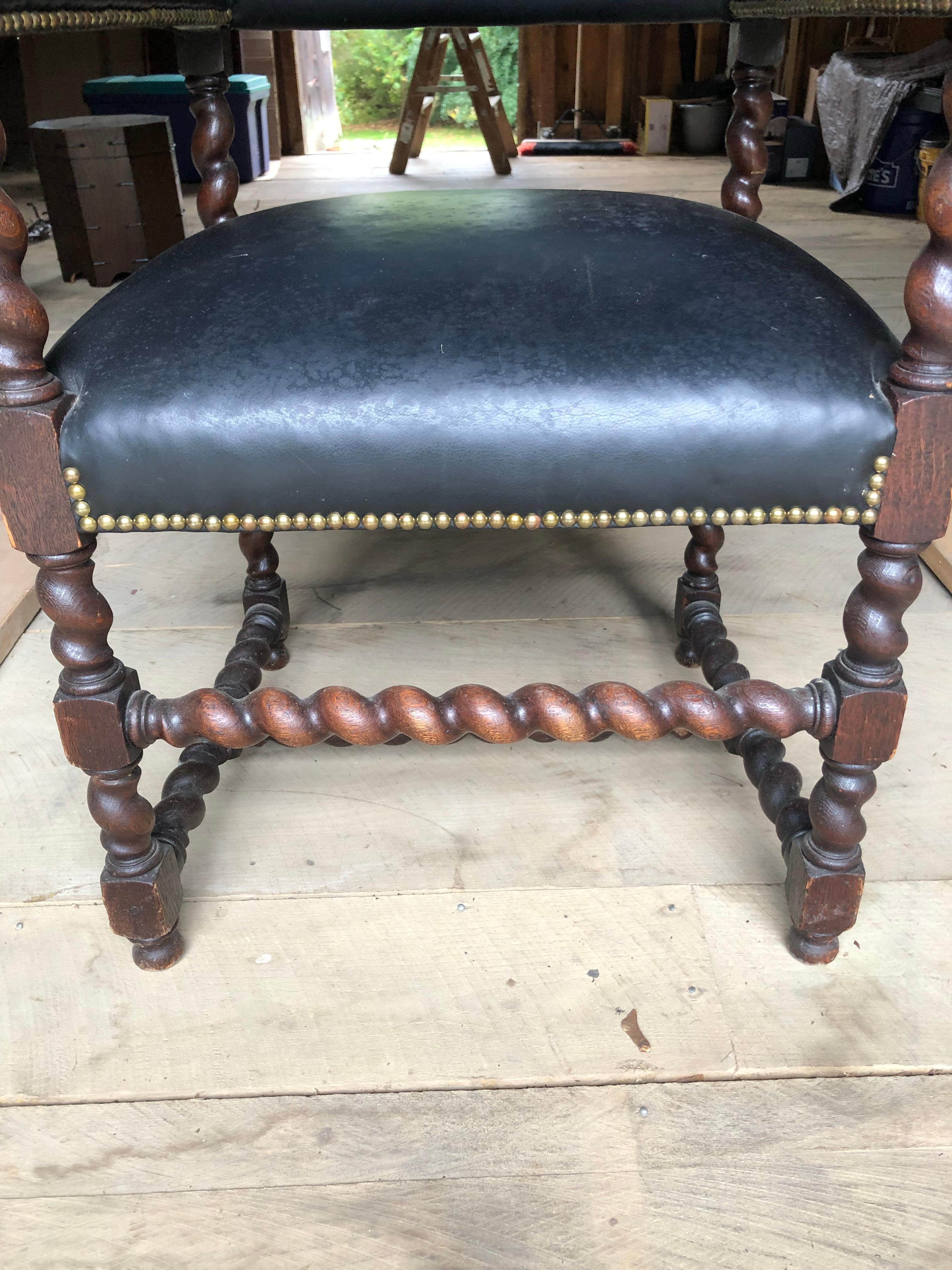Oversized handsome barley twist walnut throne shaped armchair upholstered in faux black leather.  Great looking from every angle.  Great bones but recommend reupholstery.  No rips or tears, just looks a bit tired.
Arm height 29
