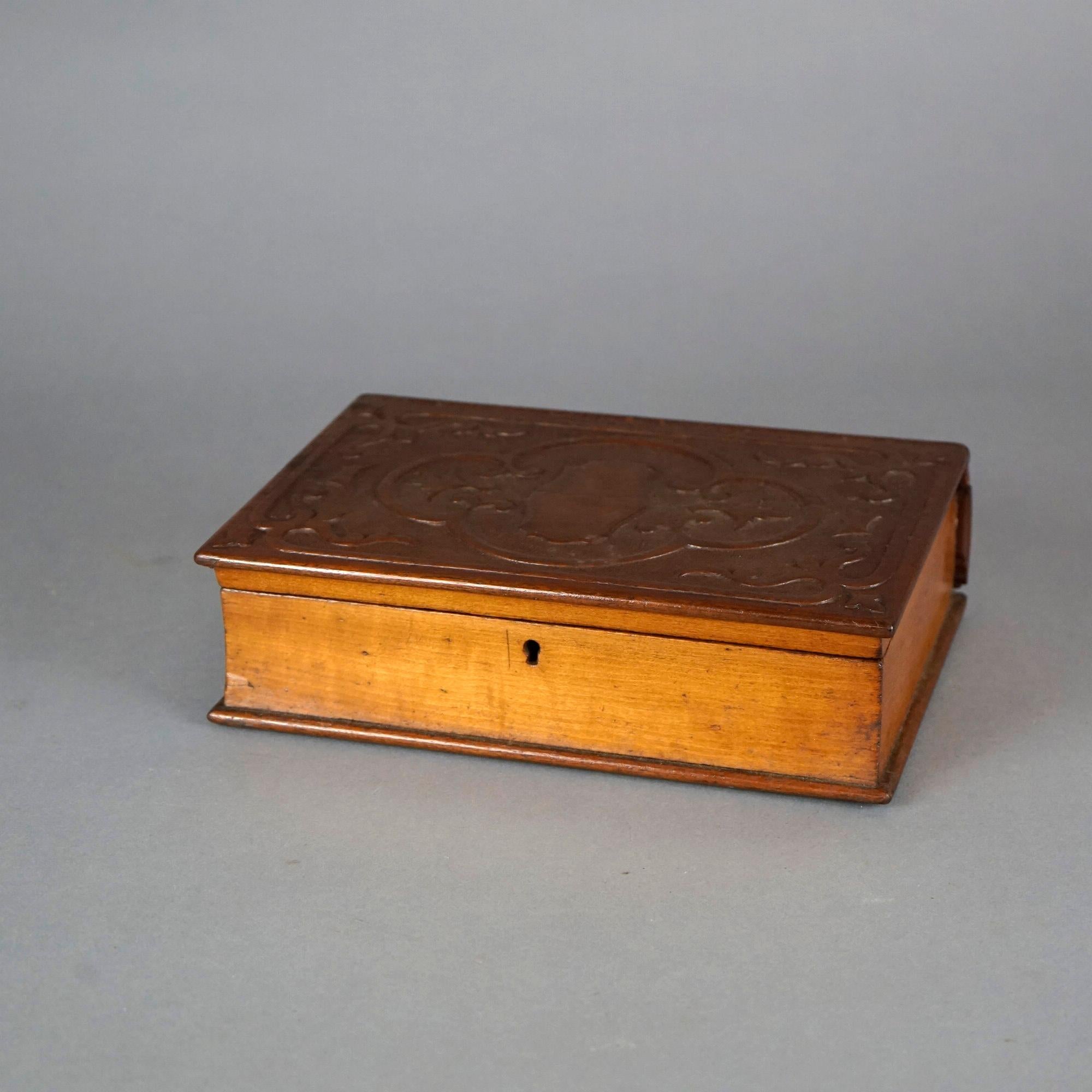 An antique book box offers carved walnut construction in the form of a book with carved scroll decoration, c1900

Measures- 10.75''H x 7.25''W x 7.25''D.