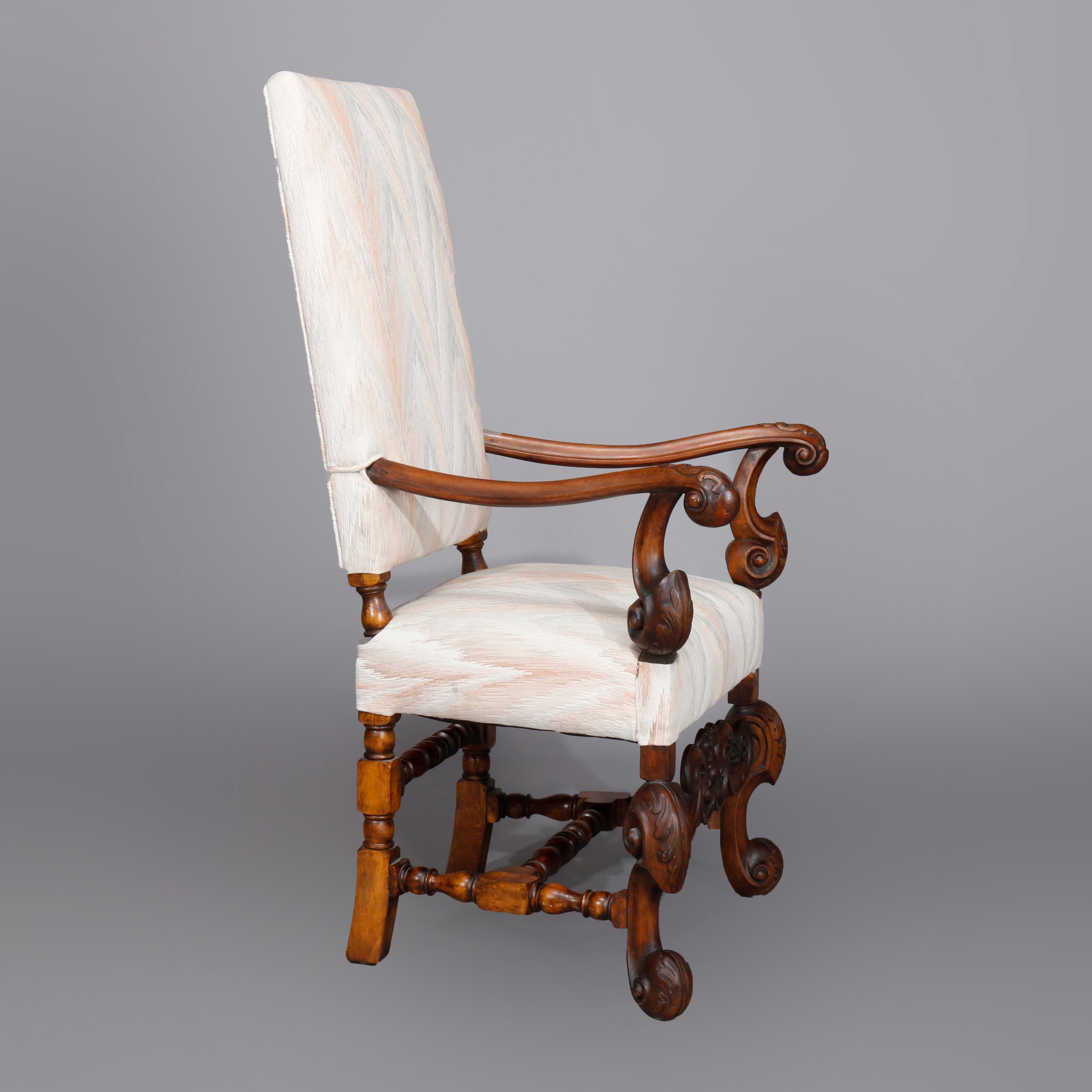 An antique pair of Continental Baroque tall fireside arm chairs offer upholstered high back and seat with carved walnut frame having scroll form flared arms, cabriole legs and stretcher, and newly upholstered, circa 1910.

Measures: 48.75