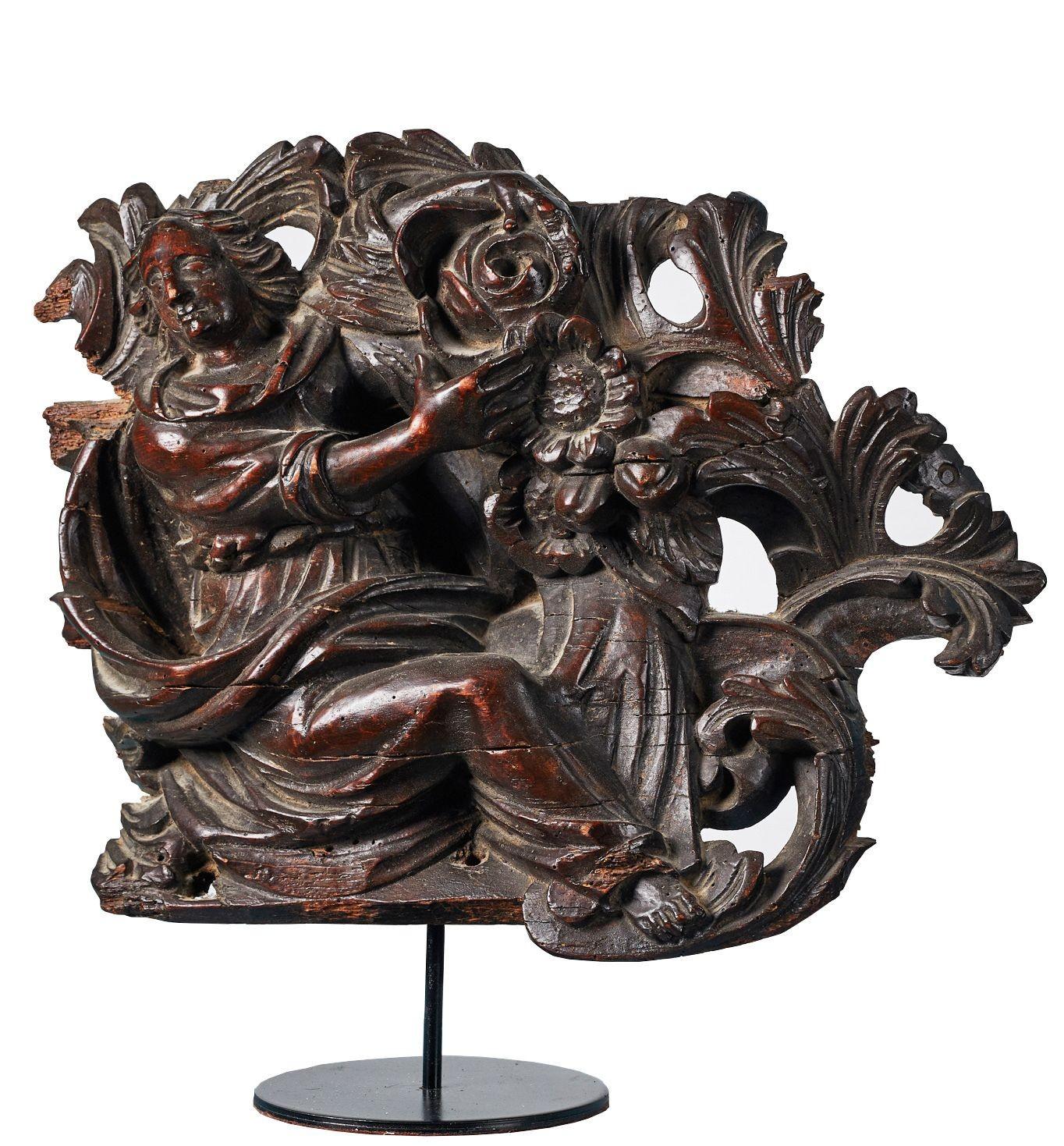 Antique carved walnut figural relief. A carved walnut figural relief depicting a lady swathed in drapery with flowers, possibly Flemish.