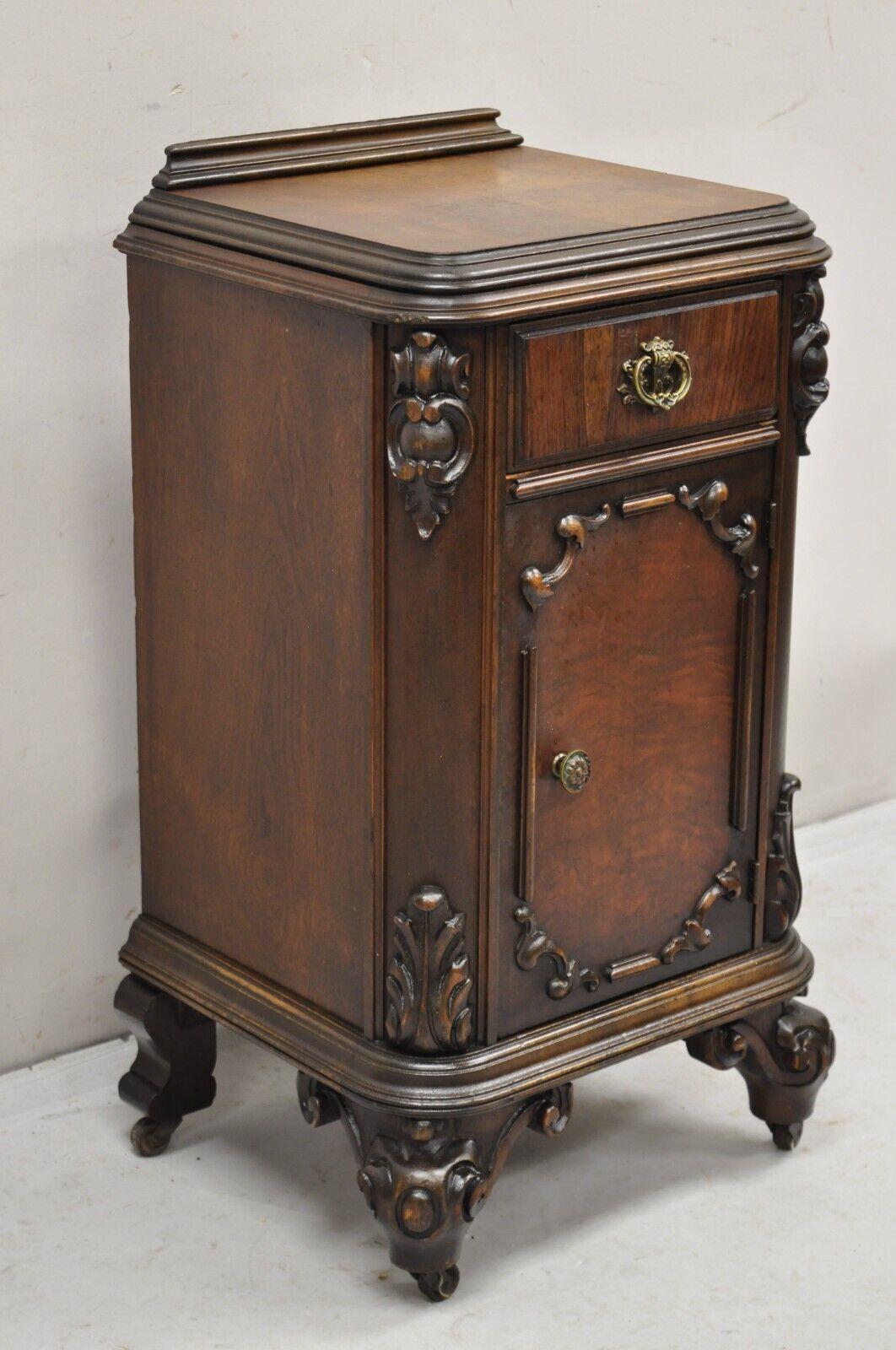 Antique Carved Walnut Renaissance Revival Depression Nightstand Bedside Table. Item features one dovetailed drawers, one swing door, nicely carved details, rolling casters. Circa Early 20th Century. Measurements: 31