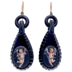 Boucles d'oreilles Whitby Jet sculptées anciennes en porcelaine dorée représentant des Cupidons dansant des putti Garlands