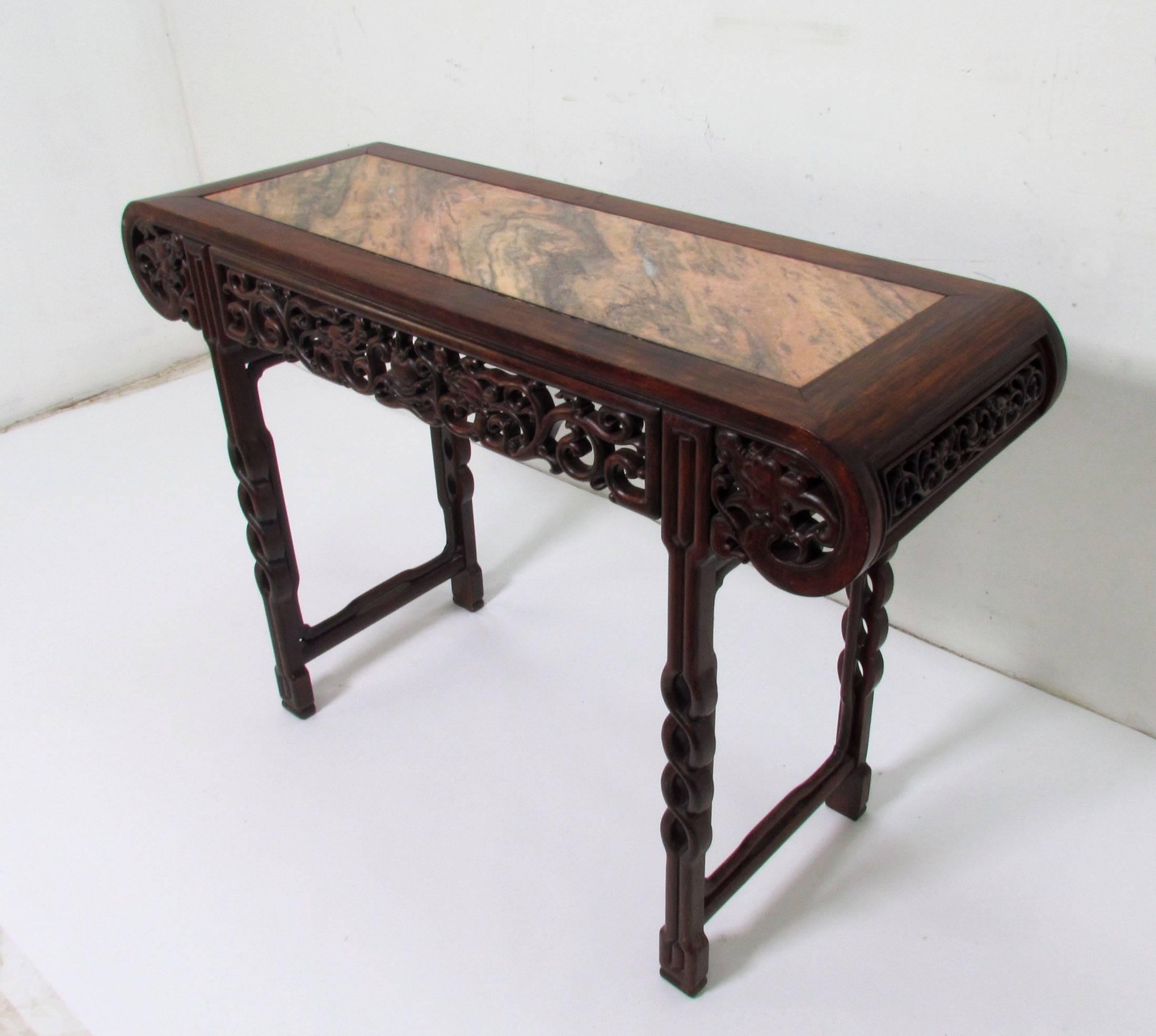 A delicately hand-carved rosewood altar or console table with open fretwork panels and leg carving.