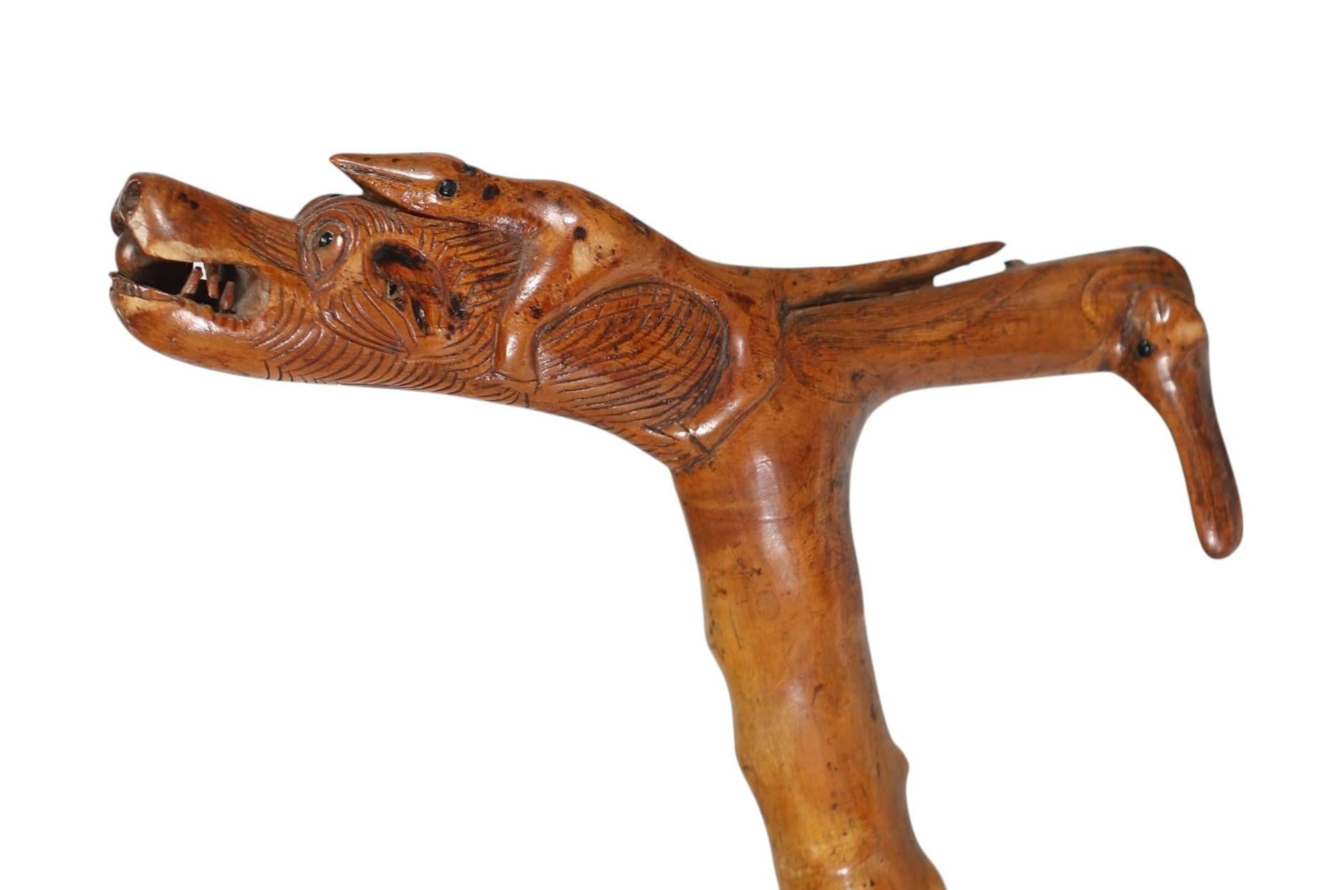 Canne ancienne en bois sculpté - Poignée fantastique avec un dragon, une salamandre et une tête de lapin
Cette canne en bois sculptée à la main est une véritable pièce d'art populaire, datant probablement de la fin du 19e siècle ou du début du 20e