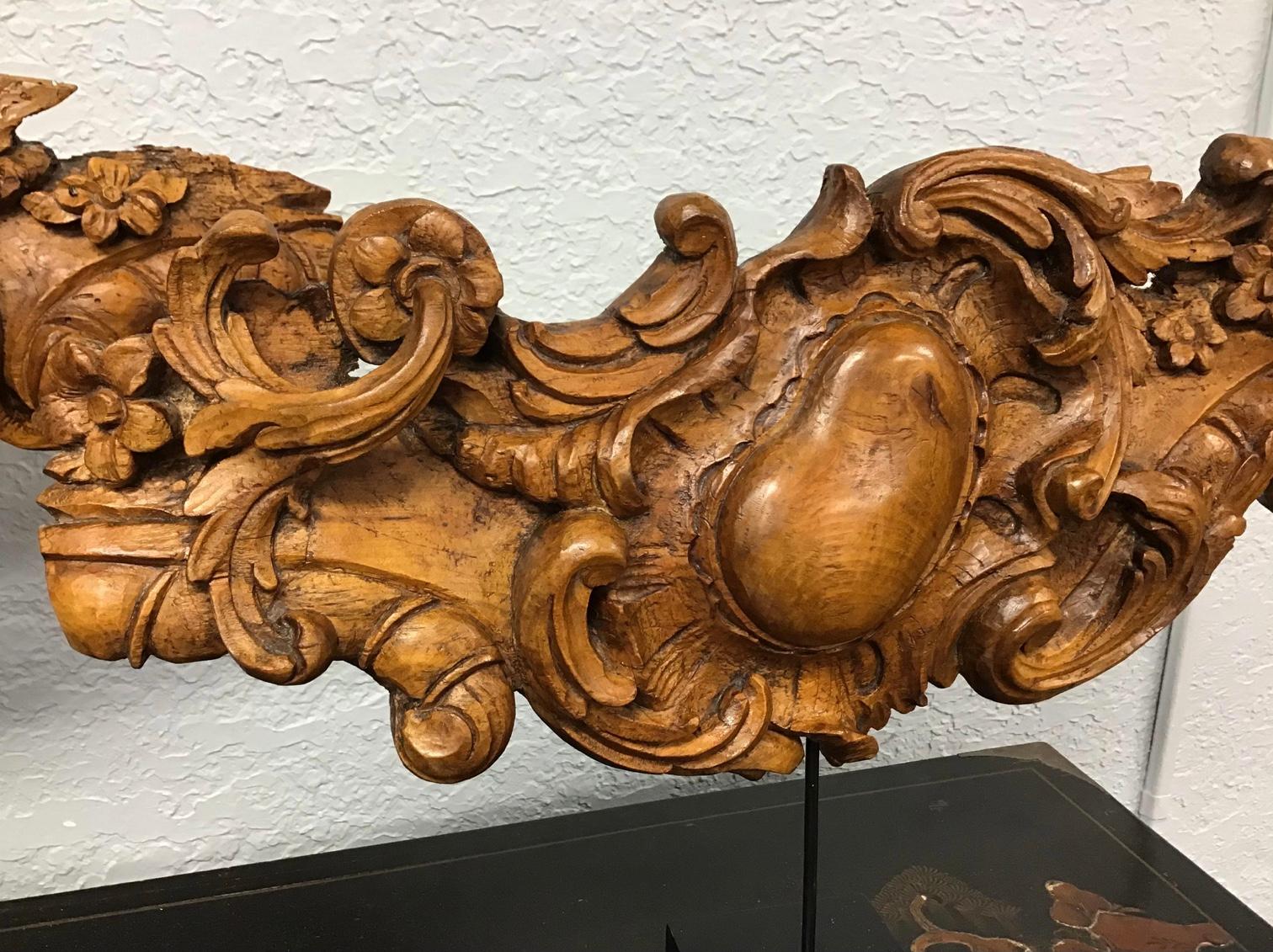 Amazing pair of 18th century carved wood cartouche. Carved with scrolling design and flowers throughout. Mounted on later iron and wood stands. Can be used on the stands on a table or chest or taken off of the stands and hung on the wall.