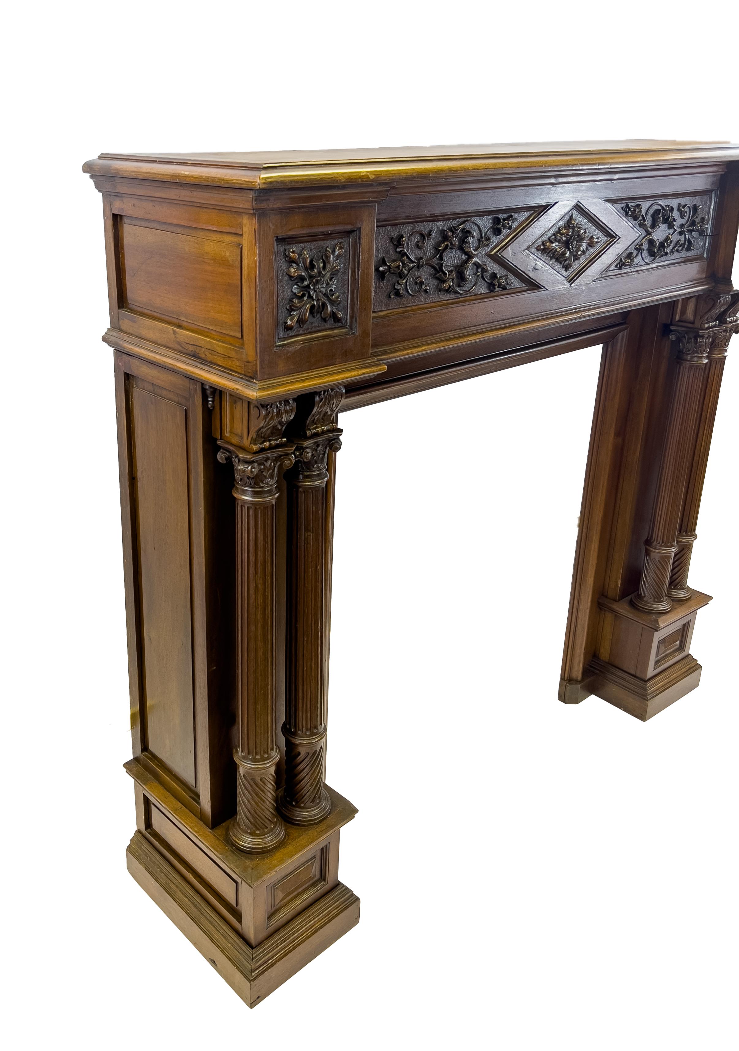 A fine fireplace mantel with beautiful details across the frame and dual round columns on both sides. 
  