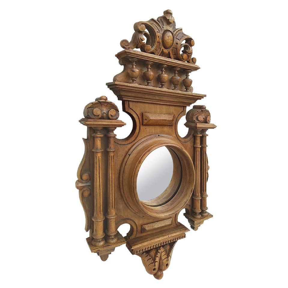 Miroir rond ancien en bois style Renaissance, période 1930. Bois sculpté ancien. Orné de colonnes, balustres, coquillages, macarons. Miroir en verre ancien. Dos en bois ancien.