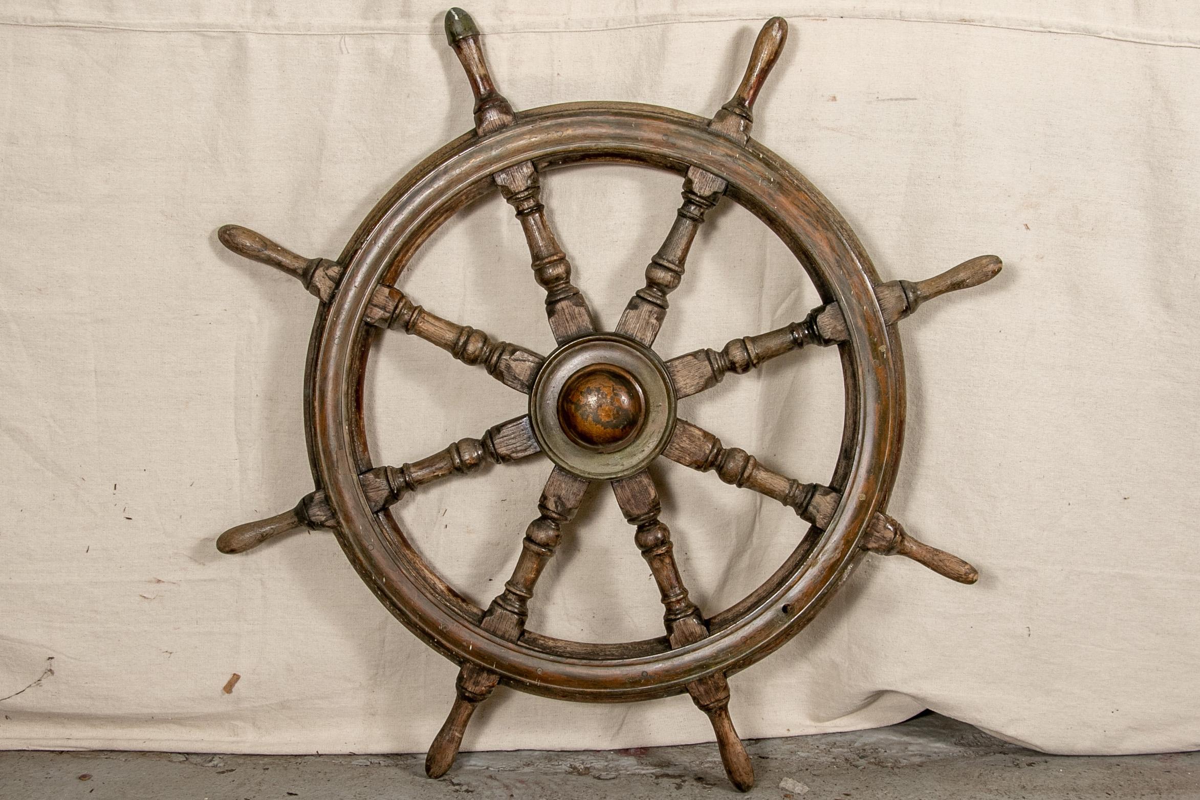 Entirely of carved wood with turned spokes. One grip with a metal cap. 

Condition: Good condition with expected signs of use and wear including well-worn overall with a few cracks as expected with use out at sea and the wheel presents very well.