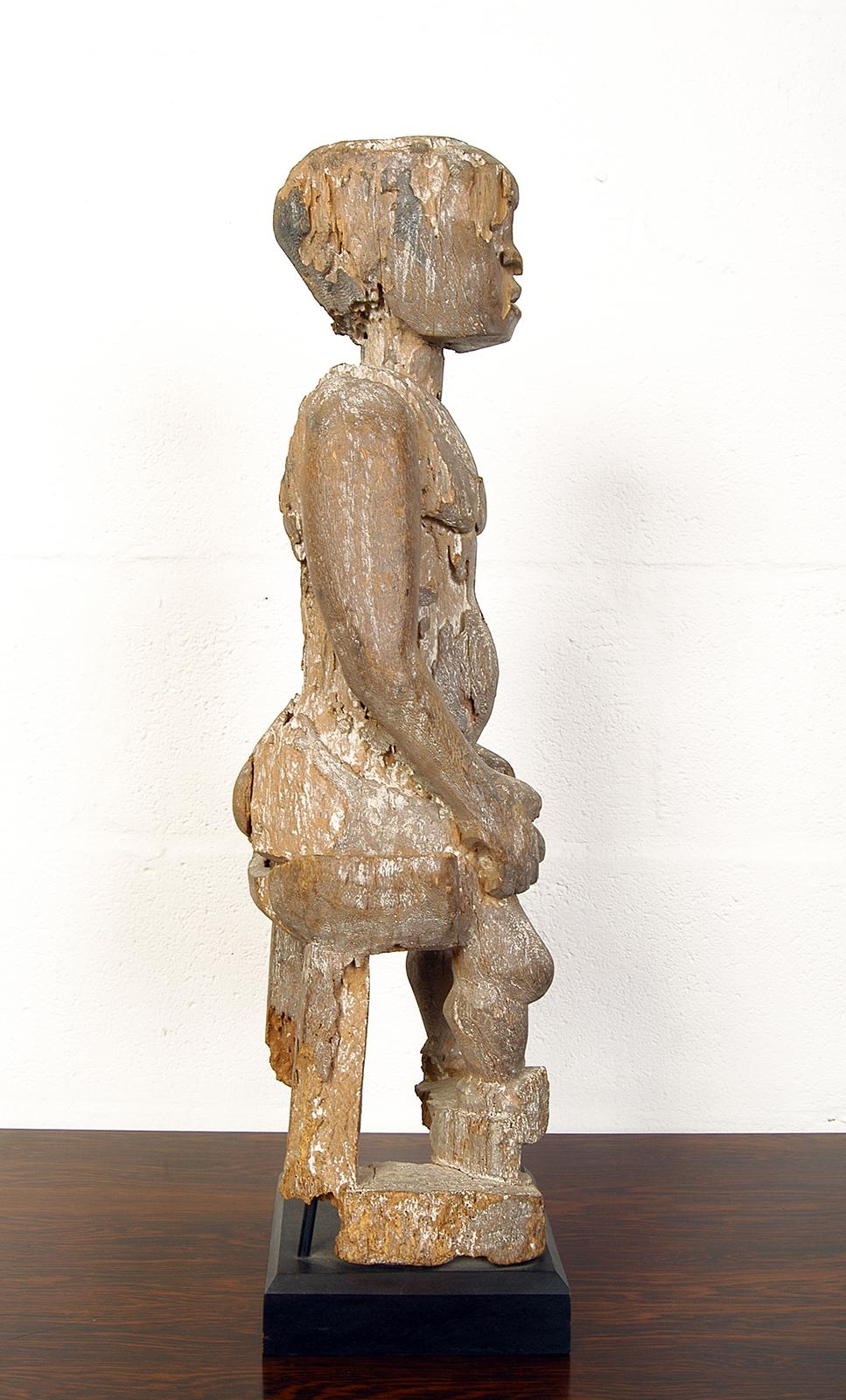 A wonderful ancient carved wooden fragment depicting a seated man with the most amazing patina – carefully mounted on a later ebonised wooden plinth. 
Standing 69cm tall, the base 17.5cm square.
             