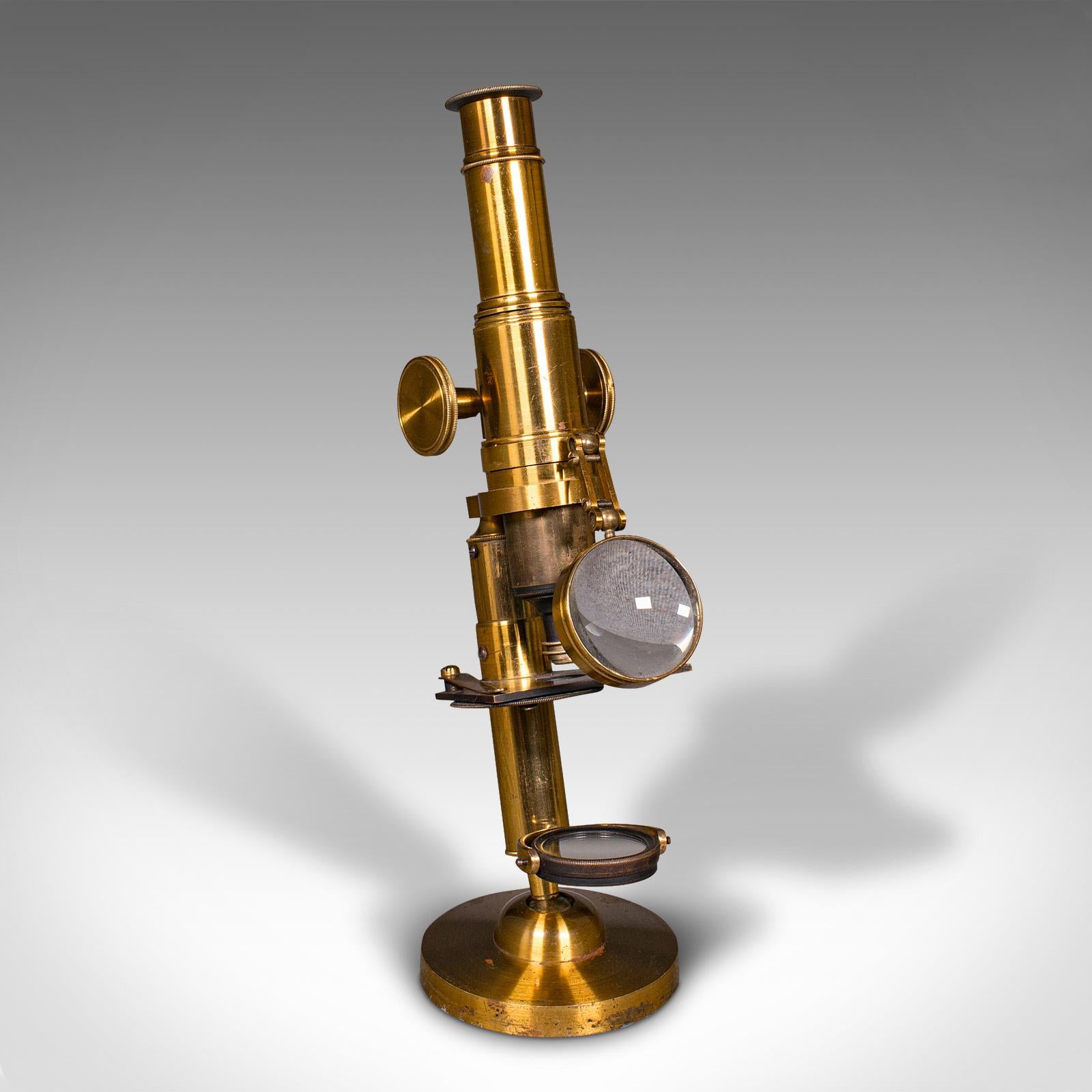 Il s'agit d'un microscope d'érudit ancien en coffret. Instrument scientifique anglais en laiton, datant du début du 20e siècle, vers 1920.

Fascinant microscope en coffret avec fonction articulée distinctive
Présente une patine d'usage désirable et
