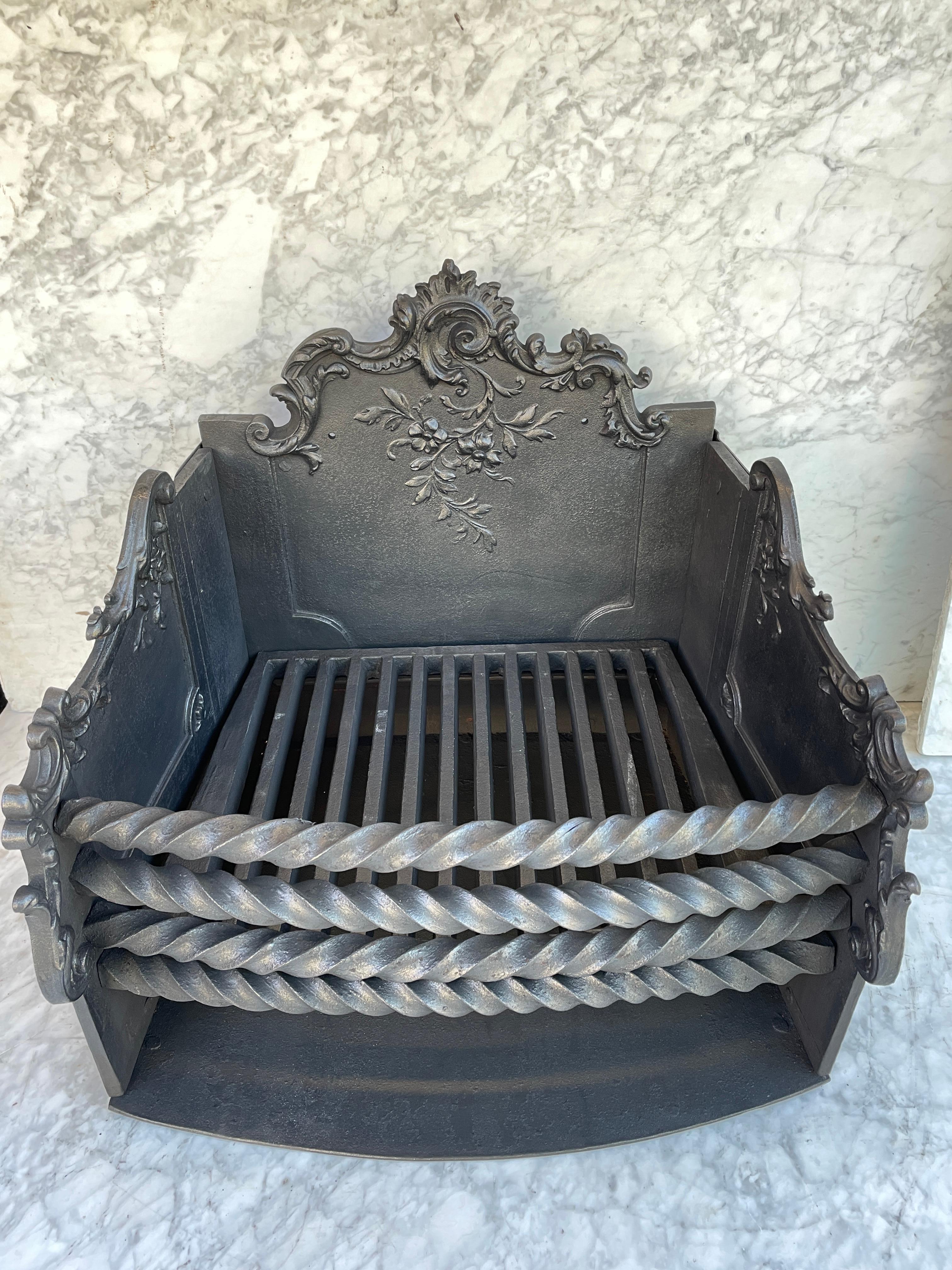 Antique cast ant wrought iron fireplace grate or basket.
This very robust and clean fire basket is a real gem. The craftmanship is visually from every corner. 
  