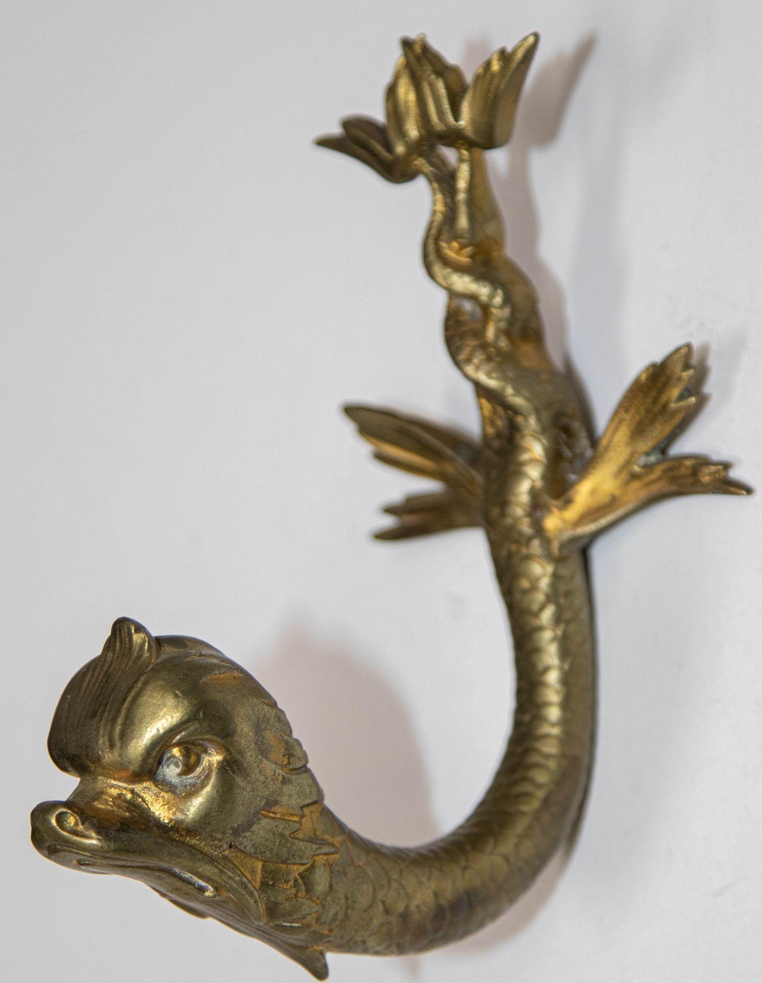 Antique Classic cast bronze koi dolphin fish wall bracket or coat hook.
Cast brass hat or coat hook in the form of a Maltese dolphin fish with a whimsical depiction of the classical mythological dolphin face with a sea serpents tail.
This French