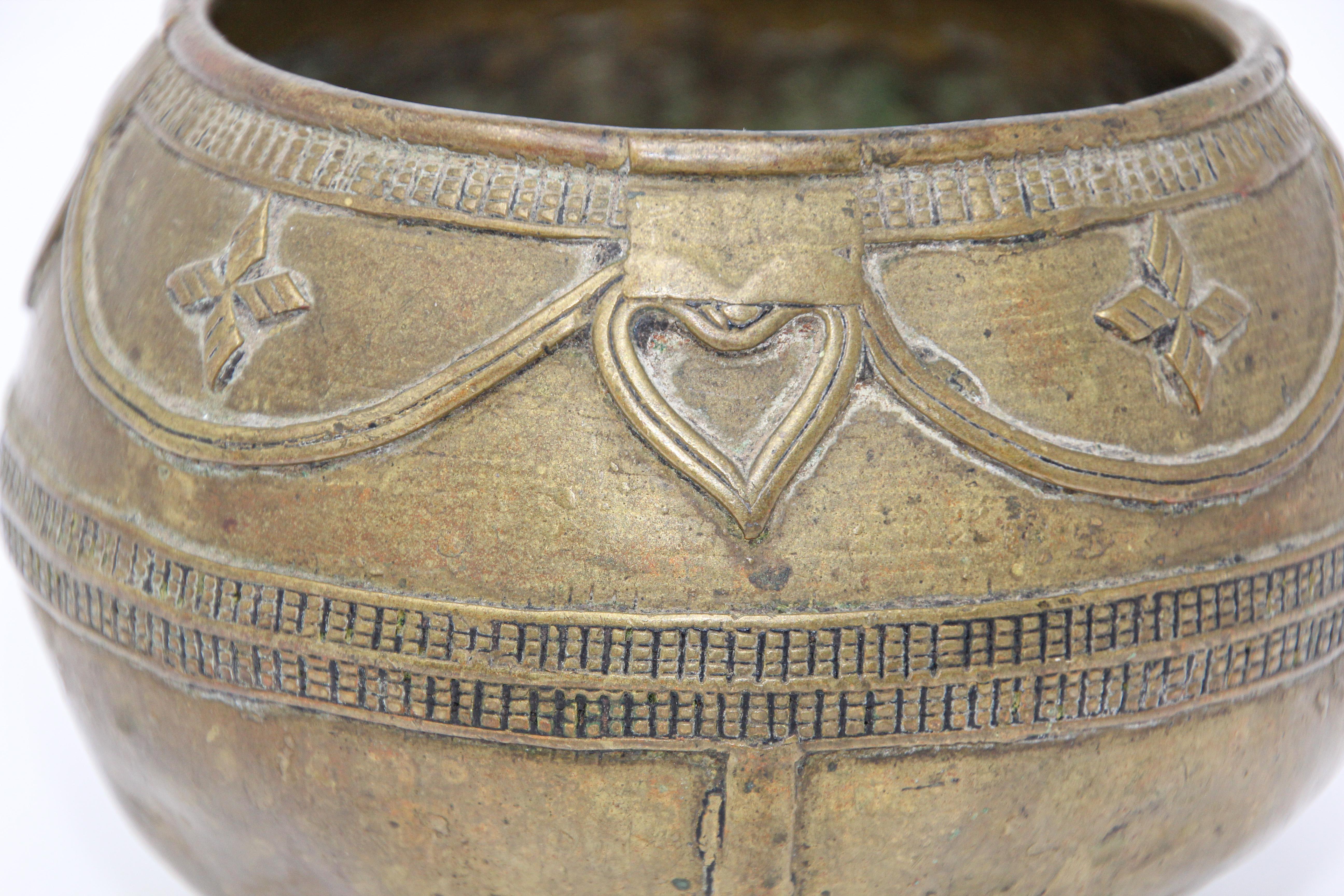 A medium sized antique cast brass measuring bowl from northern India. 
High relief casting, bundled rope maker's mark on the bottom.
Bronze rice-measuring bowl from Eastern India.
Circa 1900 collectible antique tribal bowl handmade using the lost