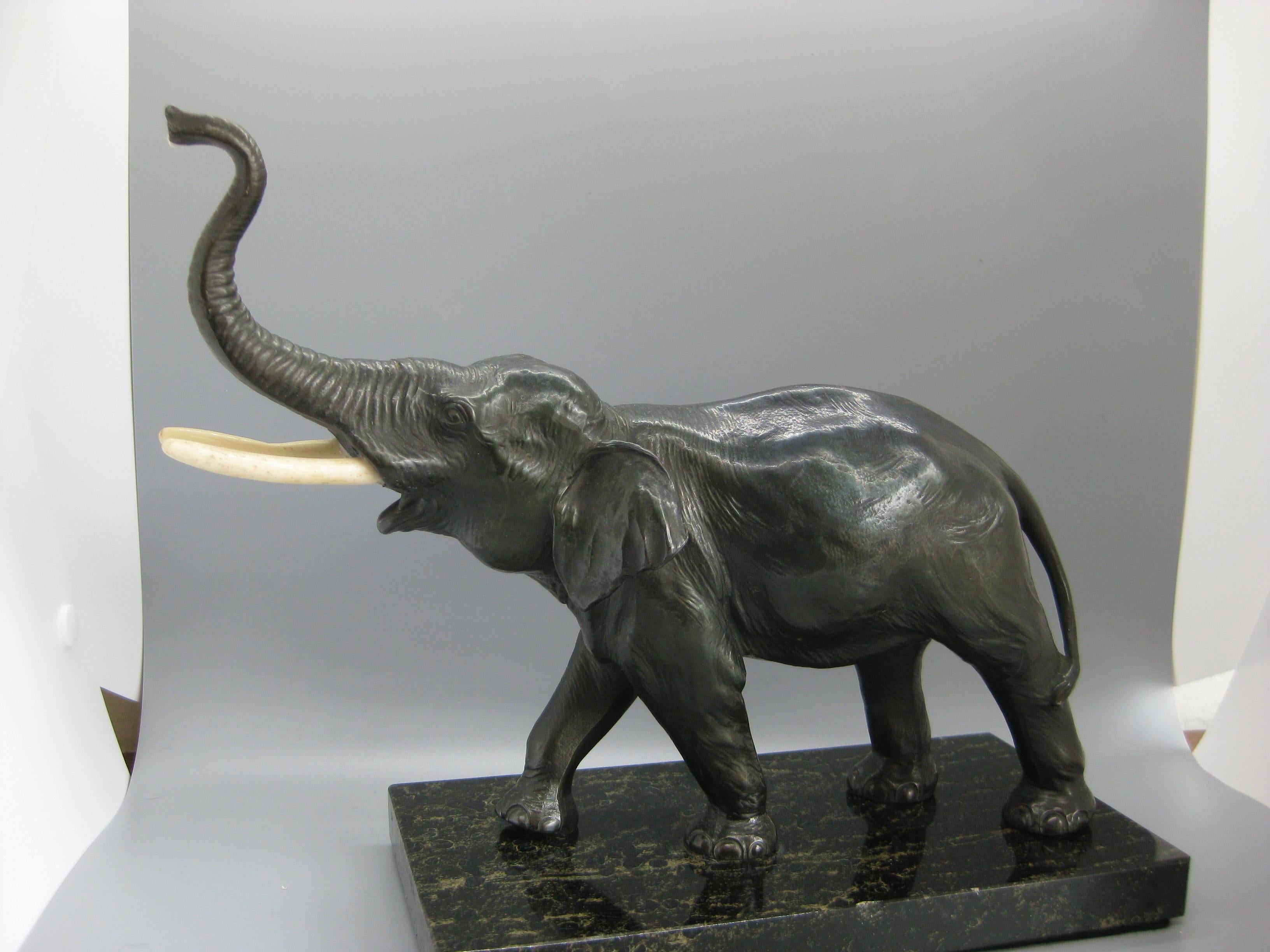 Gran escultura de elefante de bronce fundido montada sobre una base de mármol. El elefante tiene detalles maravillosos y parece que los colmillos se sustituyeron con el tiempo. La base tiene un pequeño desconchón en el borde. El elefante tiene una
