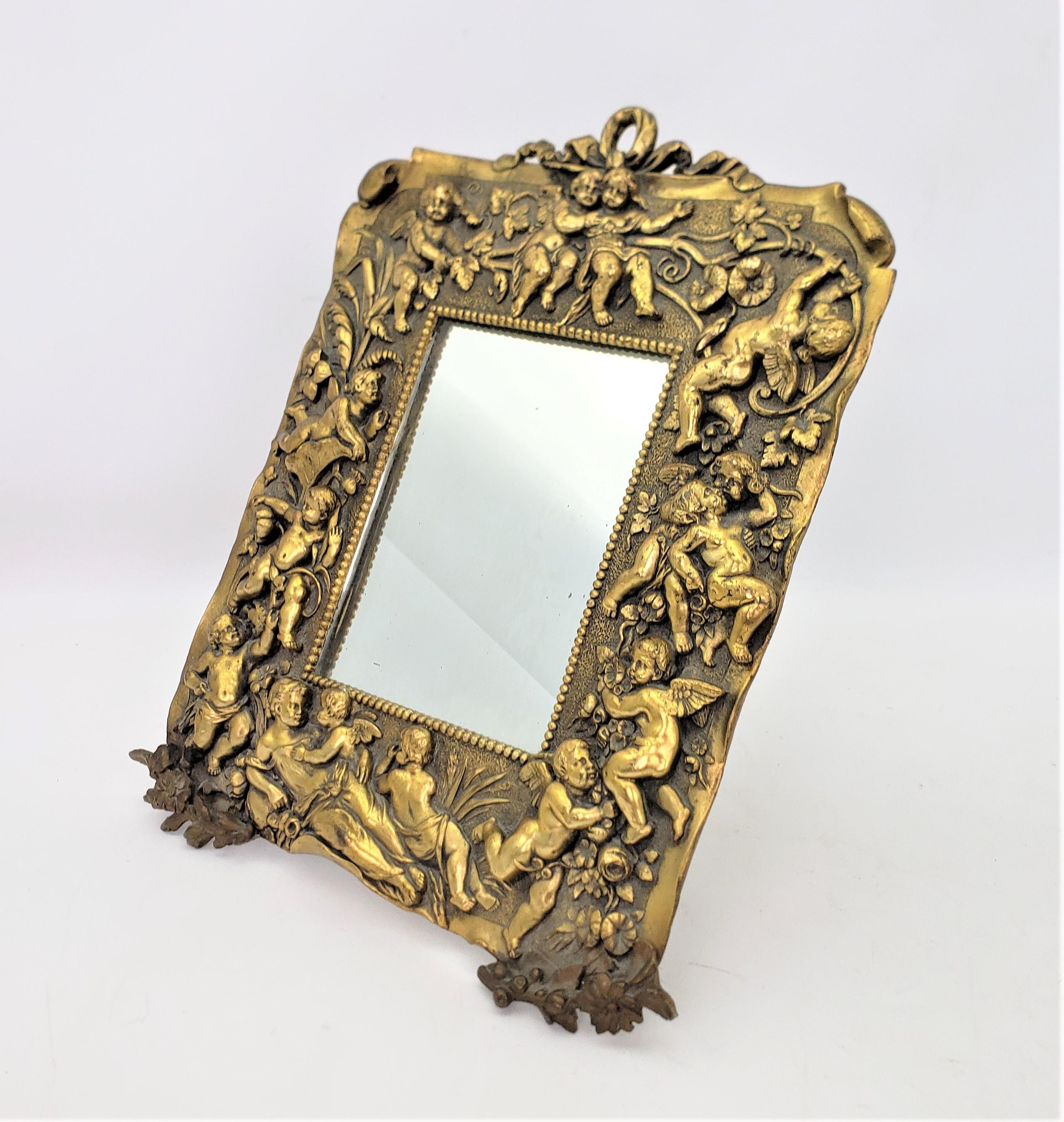 This antique cast picture frame or table mirror is unsigned, but presumed to have originated from France and dating to approximately 1900 and done in a Renaisance Revival style. The frame is composed of cast patinated bronze with a series of male