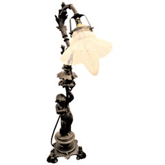Lampe de table antique en fonte avec un chérubin figuré et un abat-jour opalescent à volants