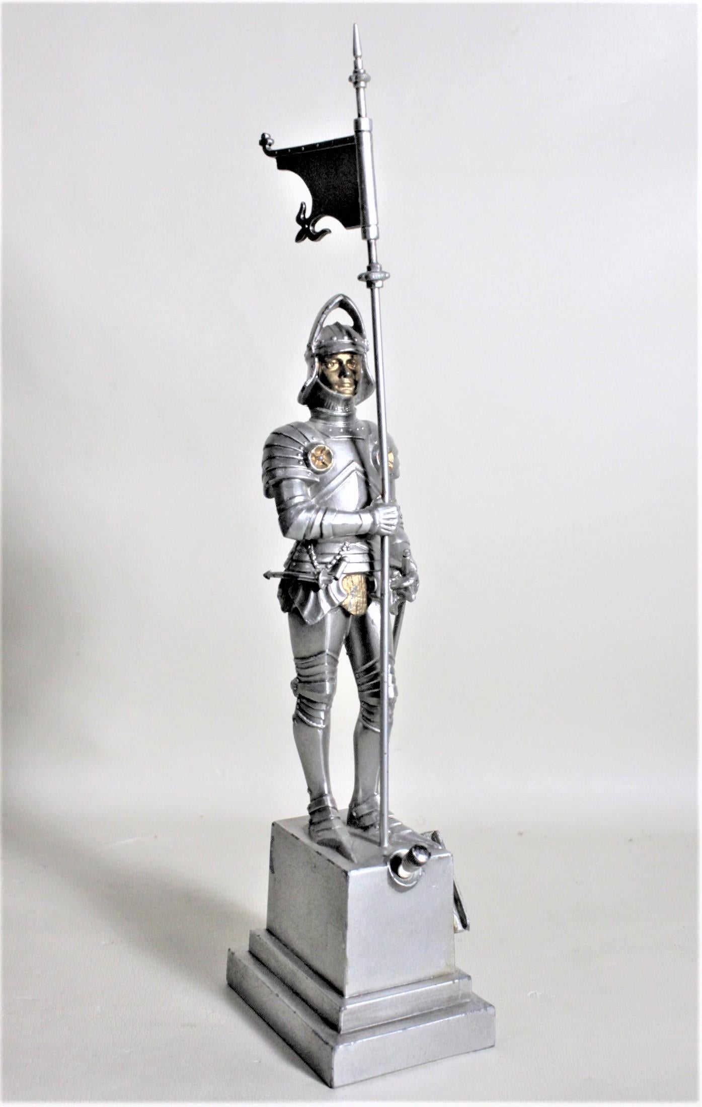 This figural cigar lighter is unsigned, but presumed to have been made in Austria in circa 1930. The lighter is a standing figural cast and cold-painted medieval knight in armor holding a flag. The casting is very detailed on all sides and has gilt