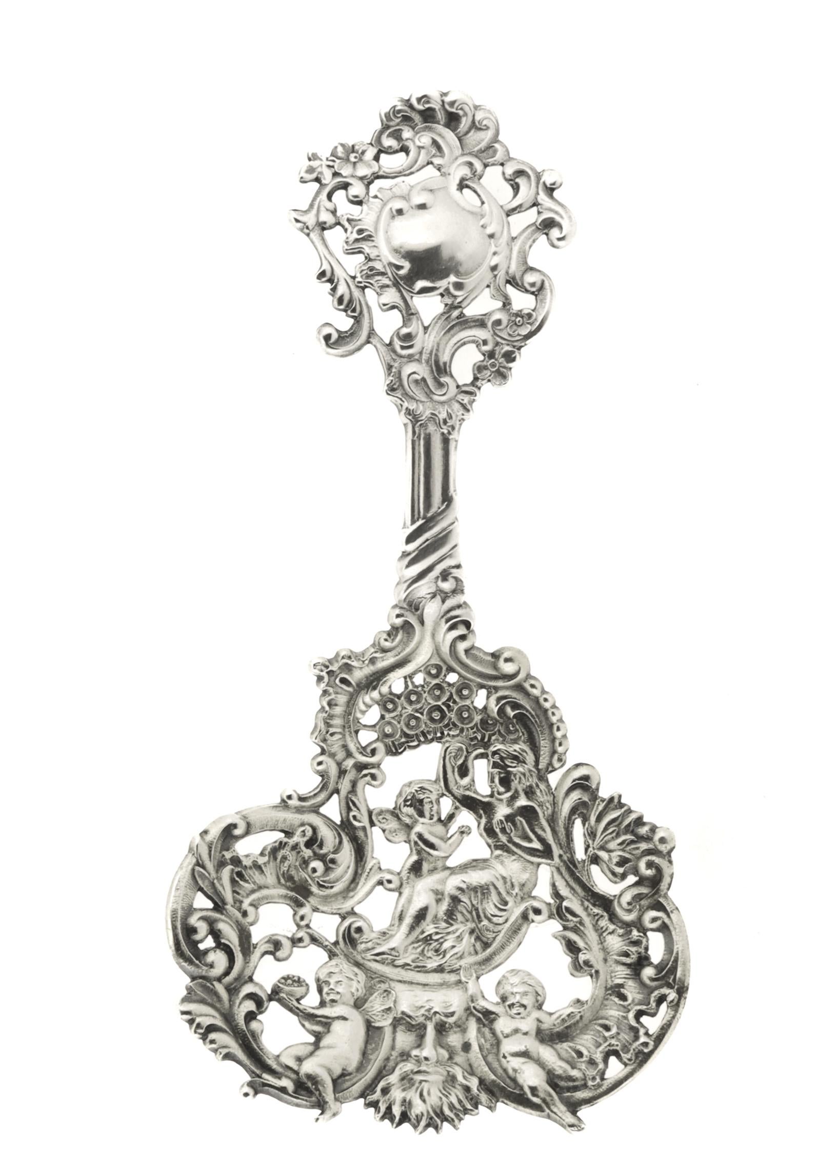 Un raffinato cucchiaio da bon bon antico.

Da Gorham.

In argento sterling fuso. 

No. 589.

Con un manico ornato e reticolato e una ciotola dorata e forata con una scena che include una donna a seno nudo e tre putti. 

Un cucchiaio Gorham