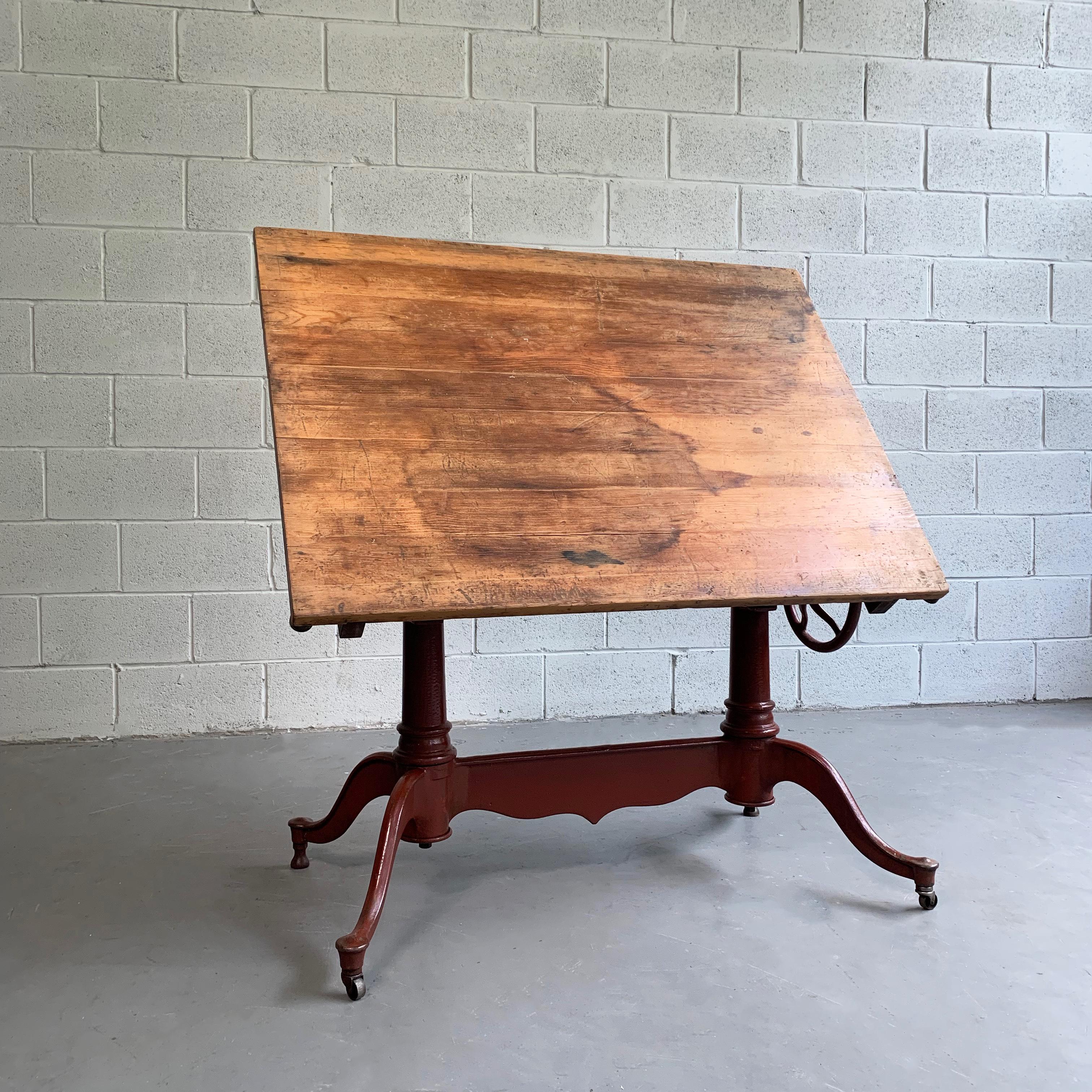 Antique, late 19th century, drafting table features a painted, cast iron base with an original pine top. The table is fully tilt adjustable and height adjustable from 32.5 - 46 inches. The foot print is 40 x 24 inches.