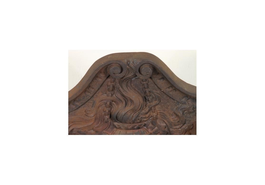 Lo schienale sagomato e decorato con una pentola fiammeggiante in rilievo, un'elaborata griglia frontale traforata a volute, sollevata da alti draghi alati sul davanti e gambe affusolate su rotelle sul retro. 

Dimensioni: 13,75 D, 19,5 H, 26