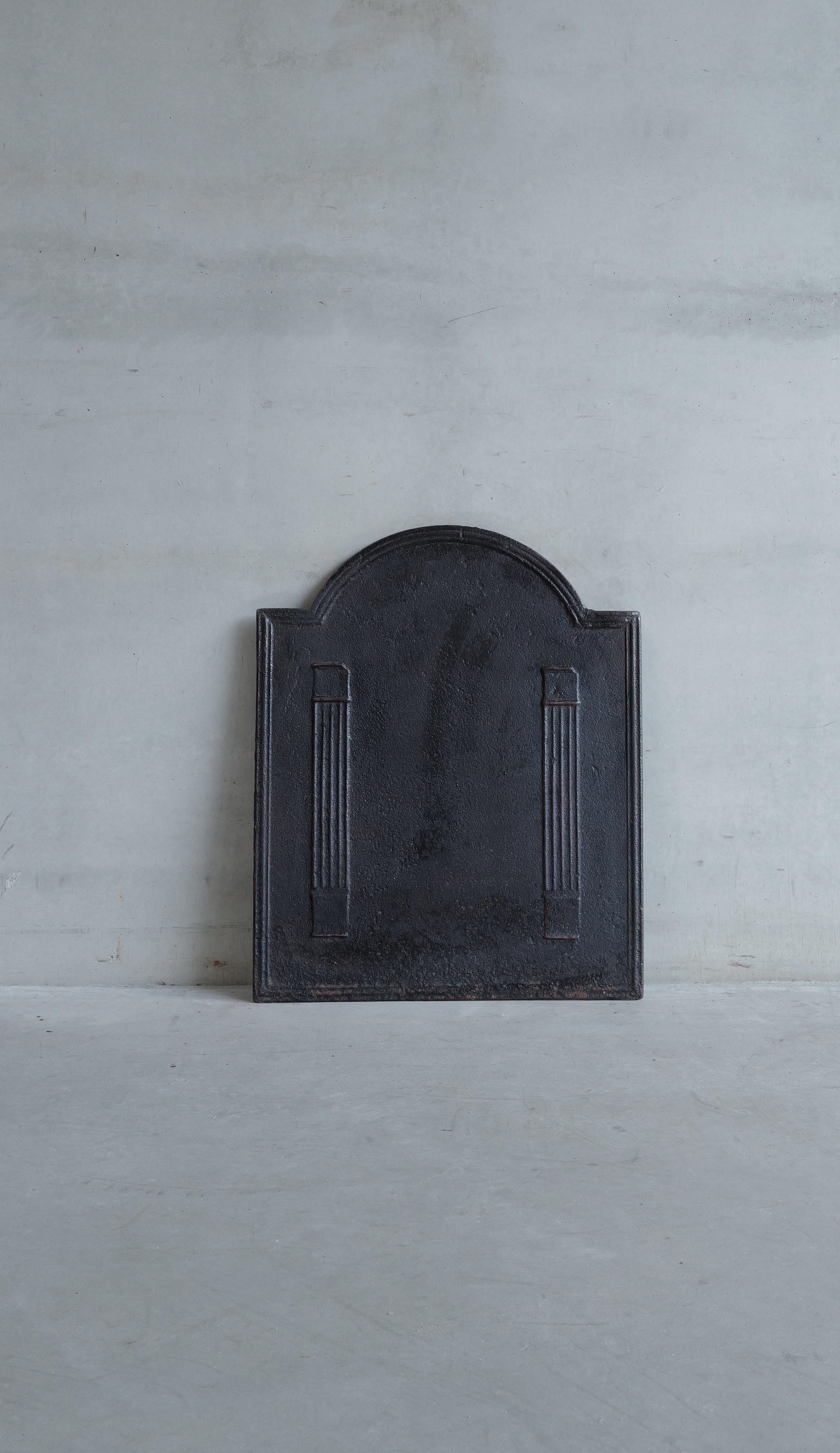 Plaque de cheminée ancienne en fonte du 19ème siècle, avec dessus rond et piliers.  