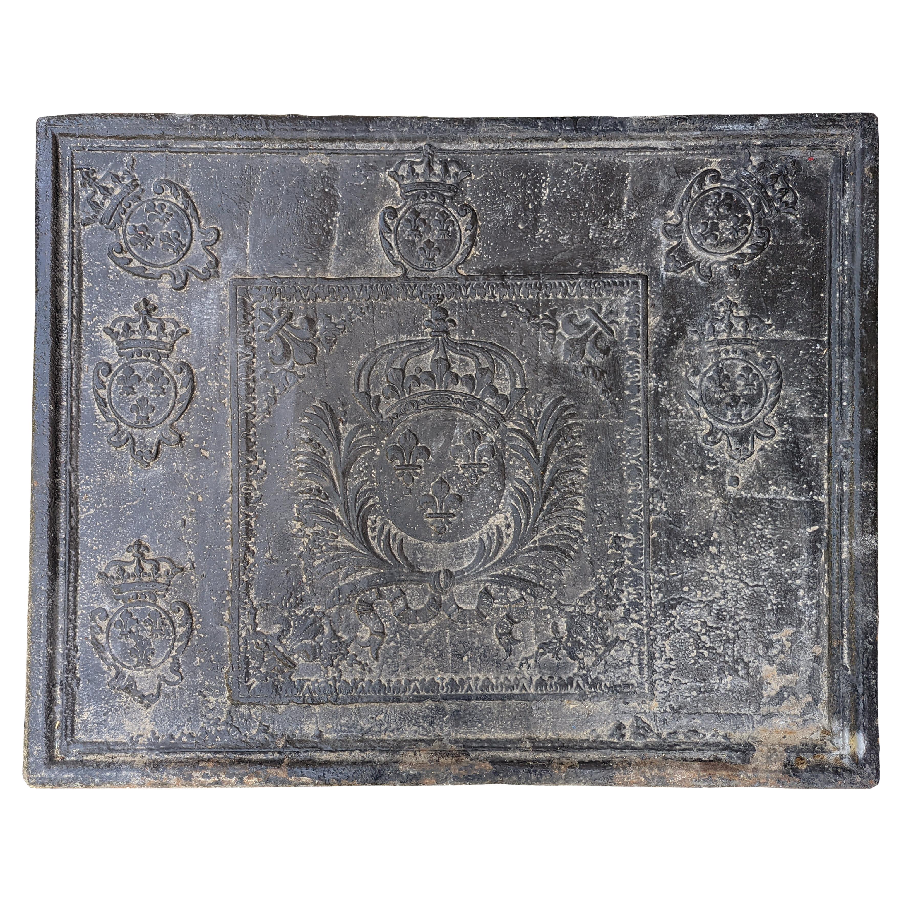 Plaque de cheminée ancienne en fonte avec les armoiries françaises du 18ème siècle