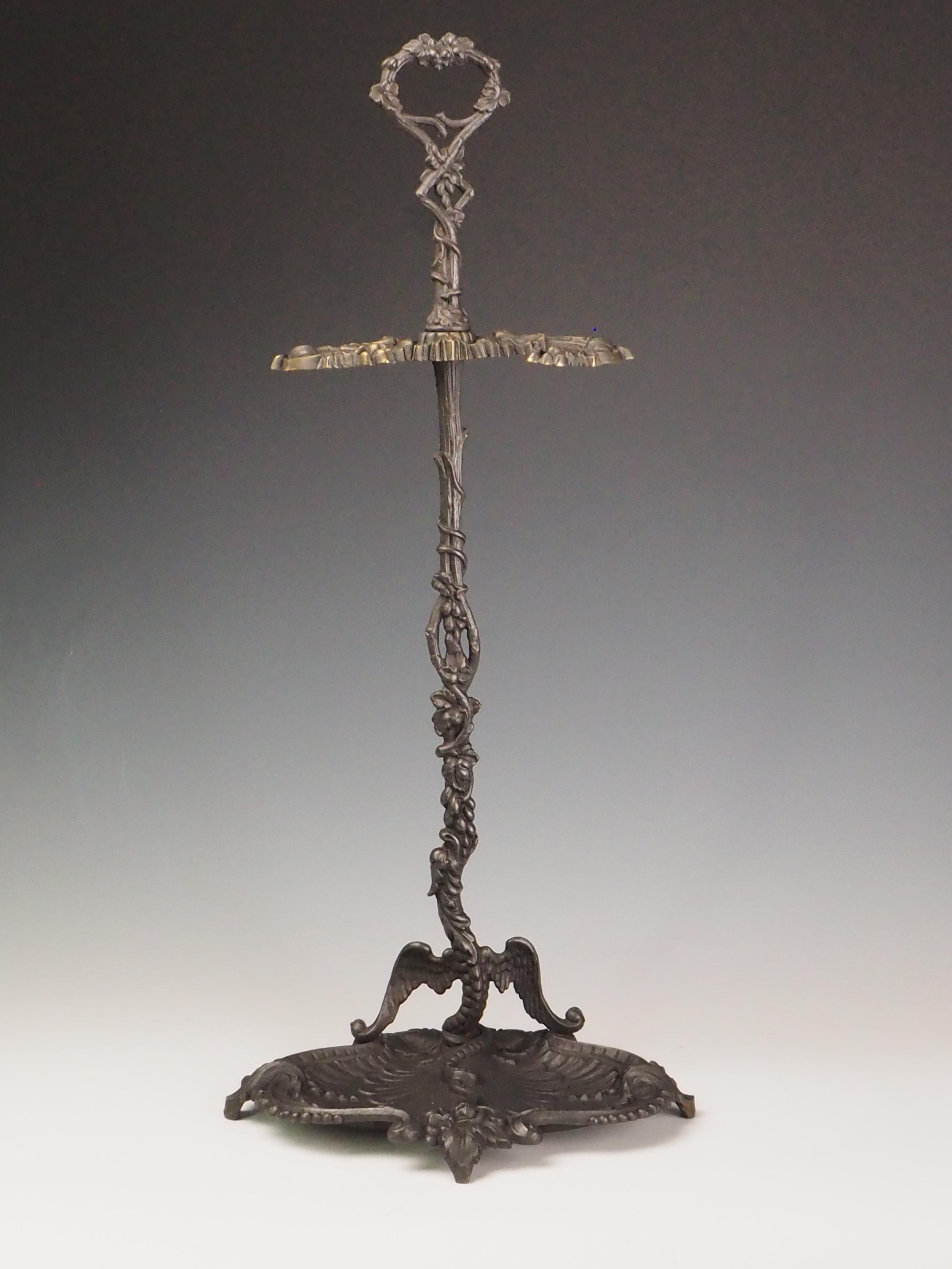 Antique Cast Iron Fireside Tool Stand  Winged Serpent Design

This Antique 19th Century Cast Iron Fireside Tool Stand is a captivating feature for any fireplace. Showcasing an intricate winged serpent motif entwined with a vine stem and a