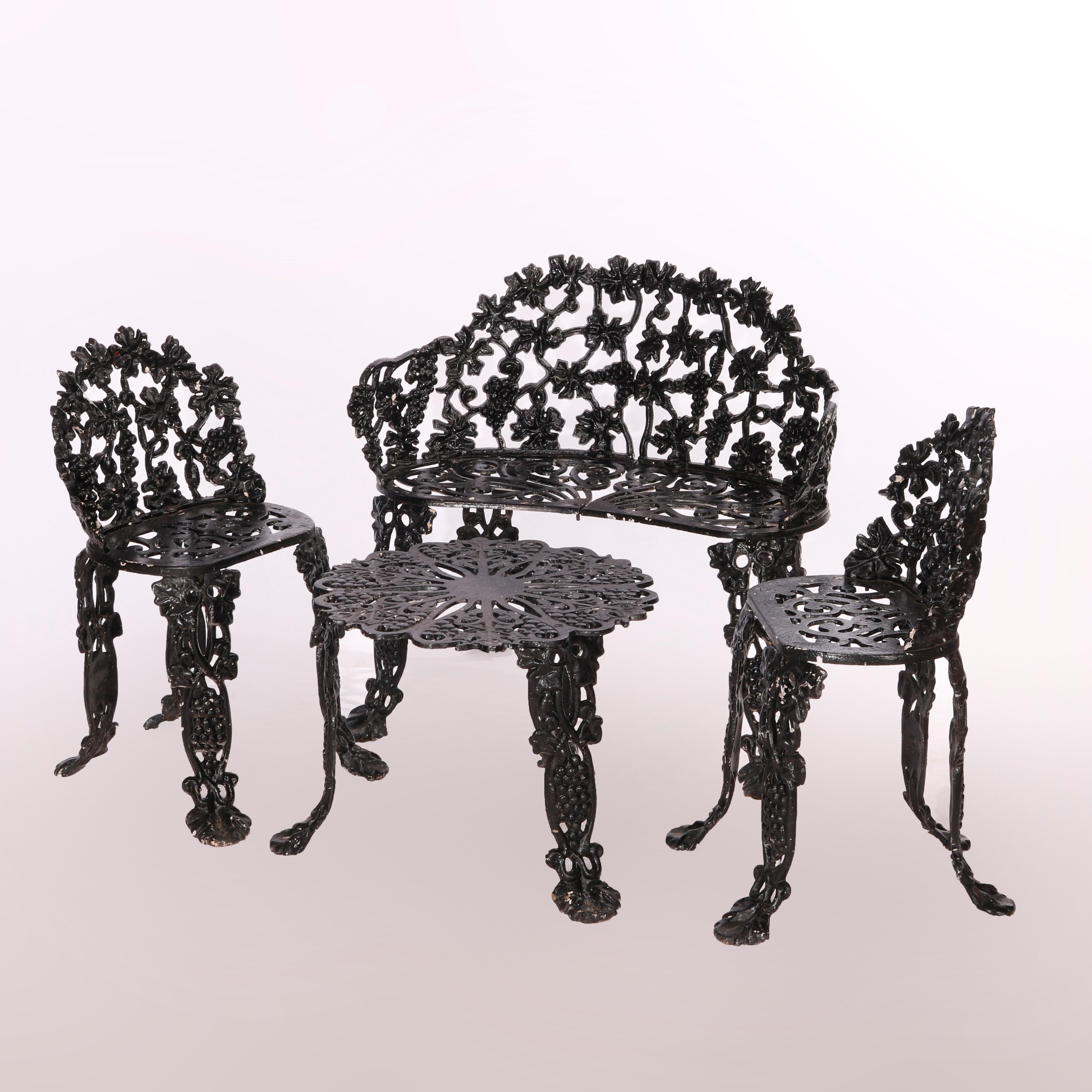 An antique garden or patio set offers pierced cast iron construction in grape and leaf pattern and includes a bench settee, two chairs and side table, c1930

Measures: Table 15.75''H x 22.25''W x 22.25''D; Chairs 27.75''H x 17.5''W x 17.5''D, seat