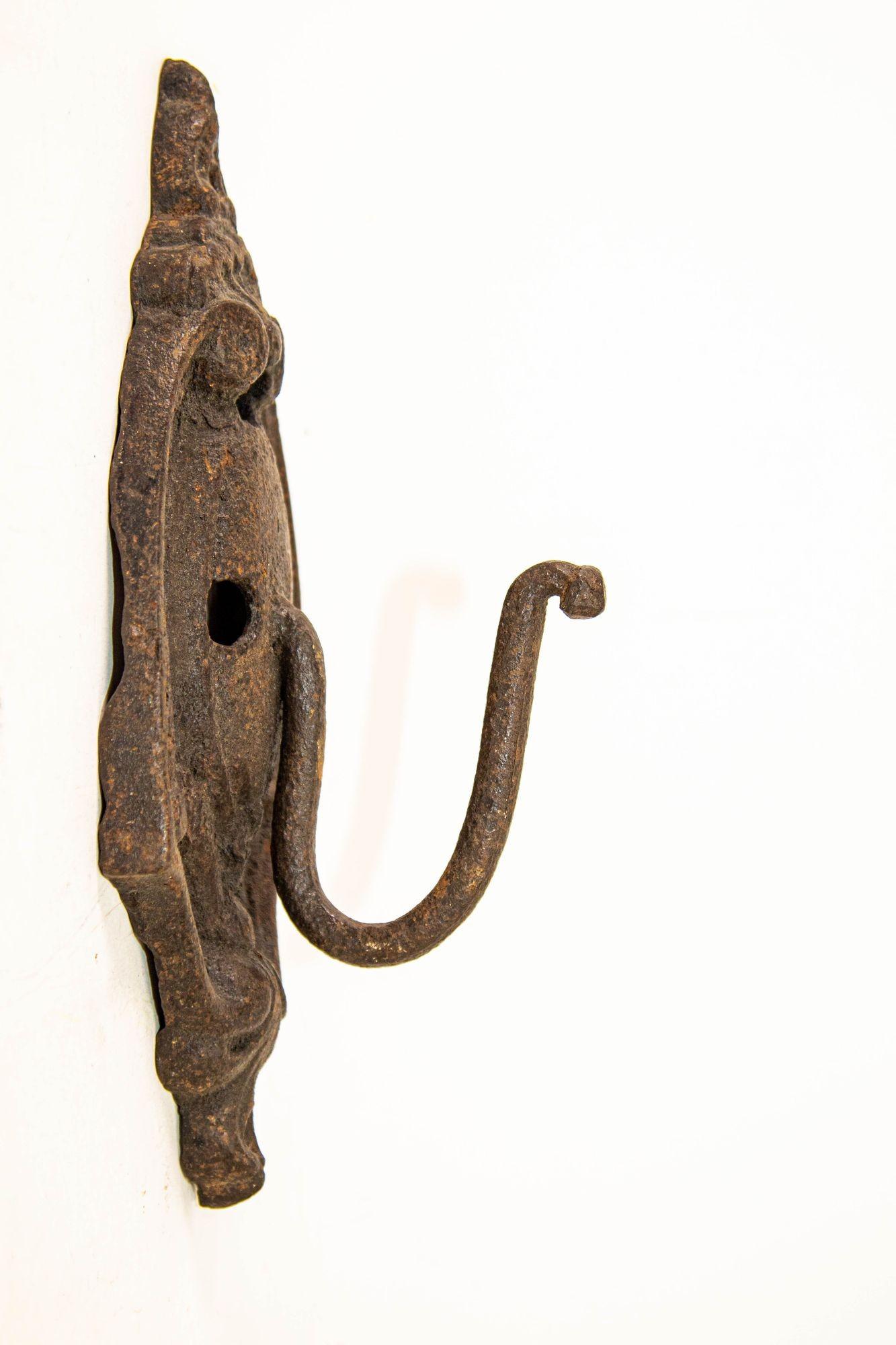 Antique Cast Iron Metal Wall Coat Hook Hanger Hardware.
This is a very unique style for a wall coat hook.
It is supported by an ornate back plate which is 10