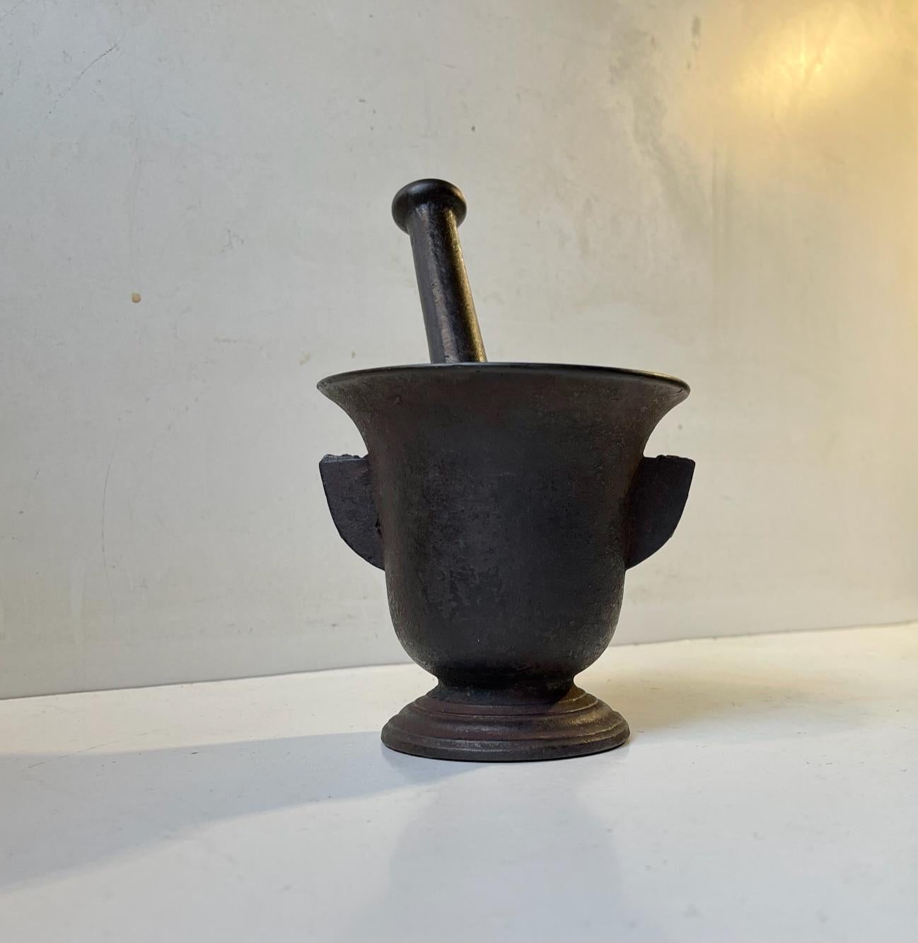 Finely proportioned, medium sized cast iron mortar and pestle. With its original finish and excellent patina. Authentic, nice and heavy. European, 19th century. Number matching mortar and pestle. Measurements: mortar: 11.5 x 10.5 cm, pestle: 18 cm