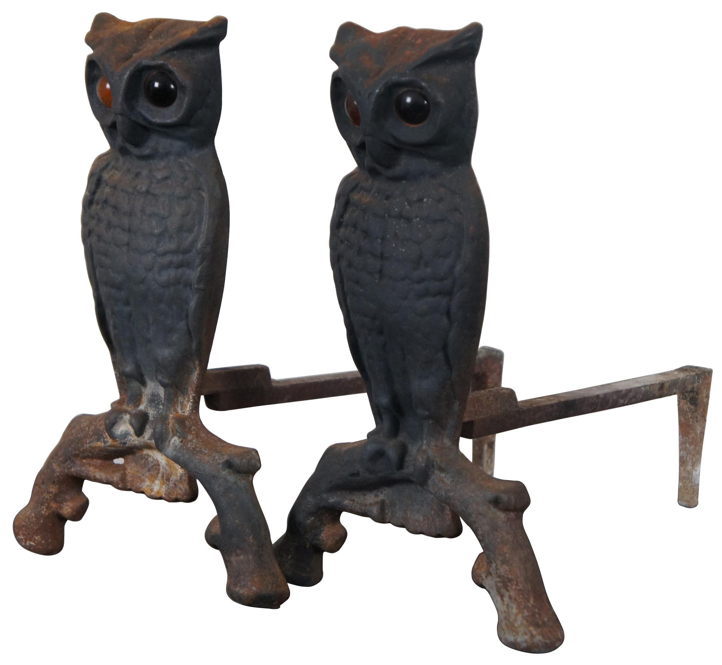 Pair of antique cast iron owl shaped fireplace andirons with orignal amber glass eyes. Measure: 13