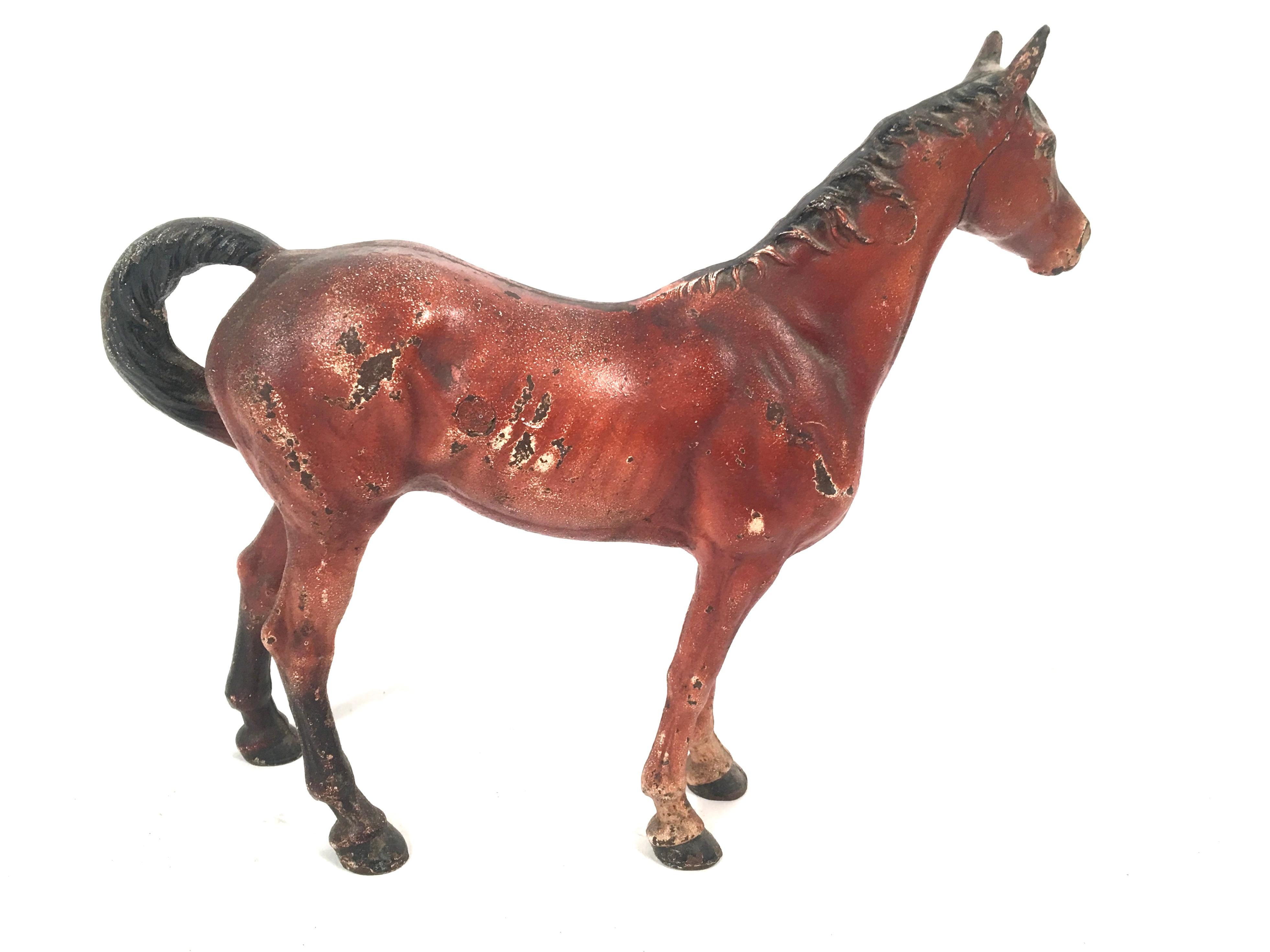 An antique painted cast iron figural horse door stop by the Hubley Manufacturing Company, American circa 1910. Substantial in weight and well modeled, retaining its original painted surface. Very functional as a doorstop or decorative as an