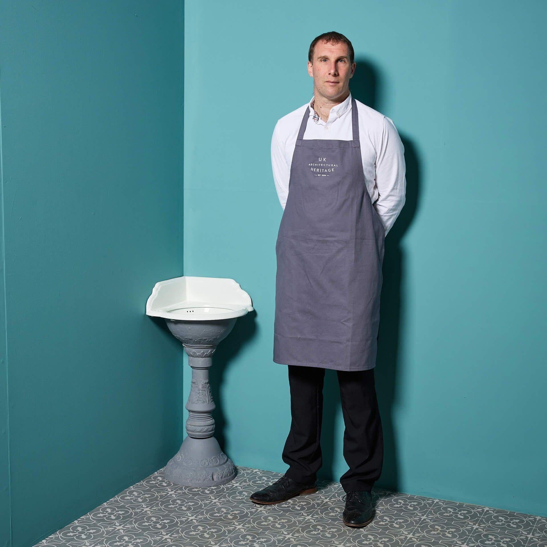 Vasque d'angle à piédestal en fonte ancienne. Produite à la fin du XIXe siècle, cette vasque présente des motifs classiques de feuilles sur le piédestal. La rouille légère et la peinture écaillée qui révèlent les anciens schémas de couleurs sont un