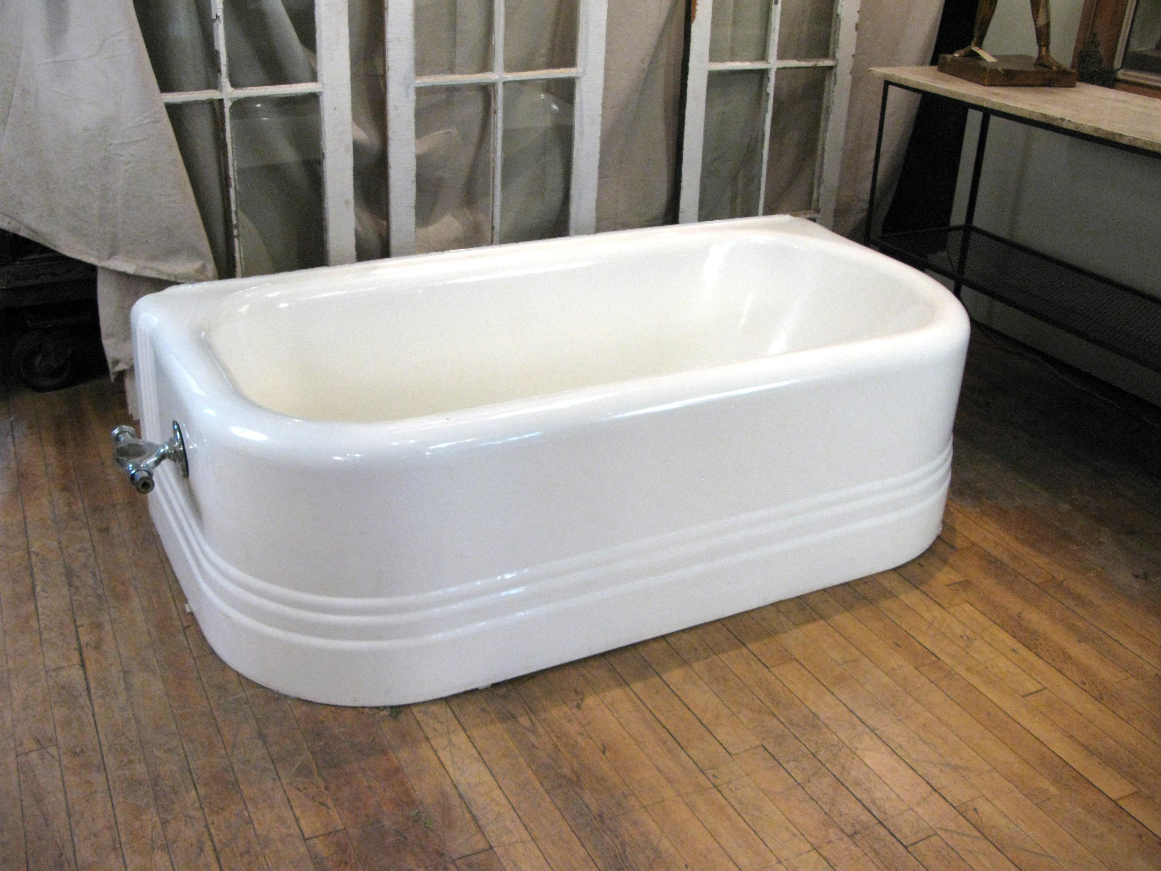 An antique cast iron low wall soaking bathtub, from the Harold Brown Villa in Newport, RI. Beautiful design exposed on three sides, with a low profile making it easy to step in and out of.