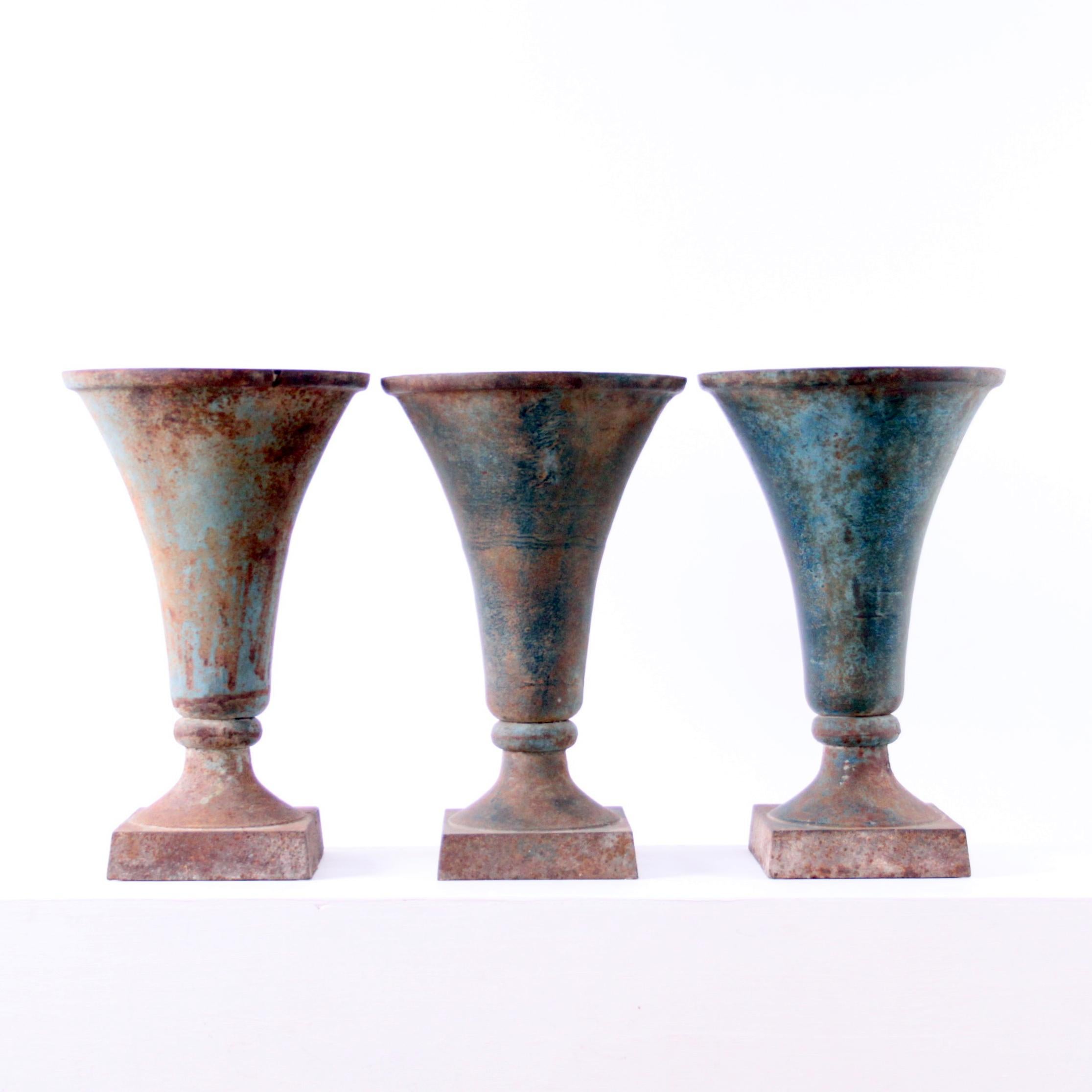 A set of three beautiful antique vases in cast iron with patina. 

The vases have been acquired by former owner in Paris and have been used as center pieces in a Copenhagen flower shop.

They be used both as vases and as a jardinière.

Excellent