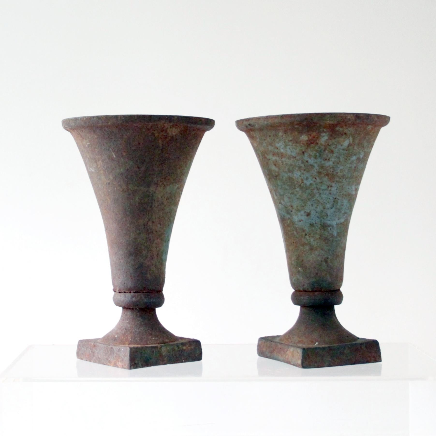 A set of two beautiful antique vases in cast iron with patina. 

The vases have been acquired by former owner in Paris and have been used as center pieces in a Copenhagen flower shop.

They be used both as vases and as a jardinière.

Excellent
