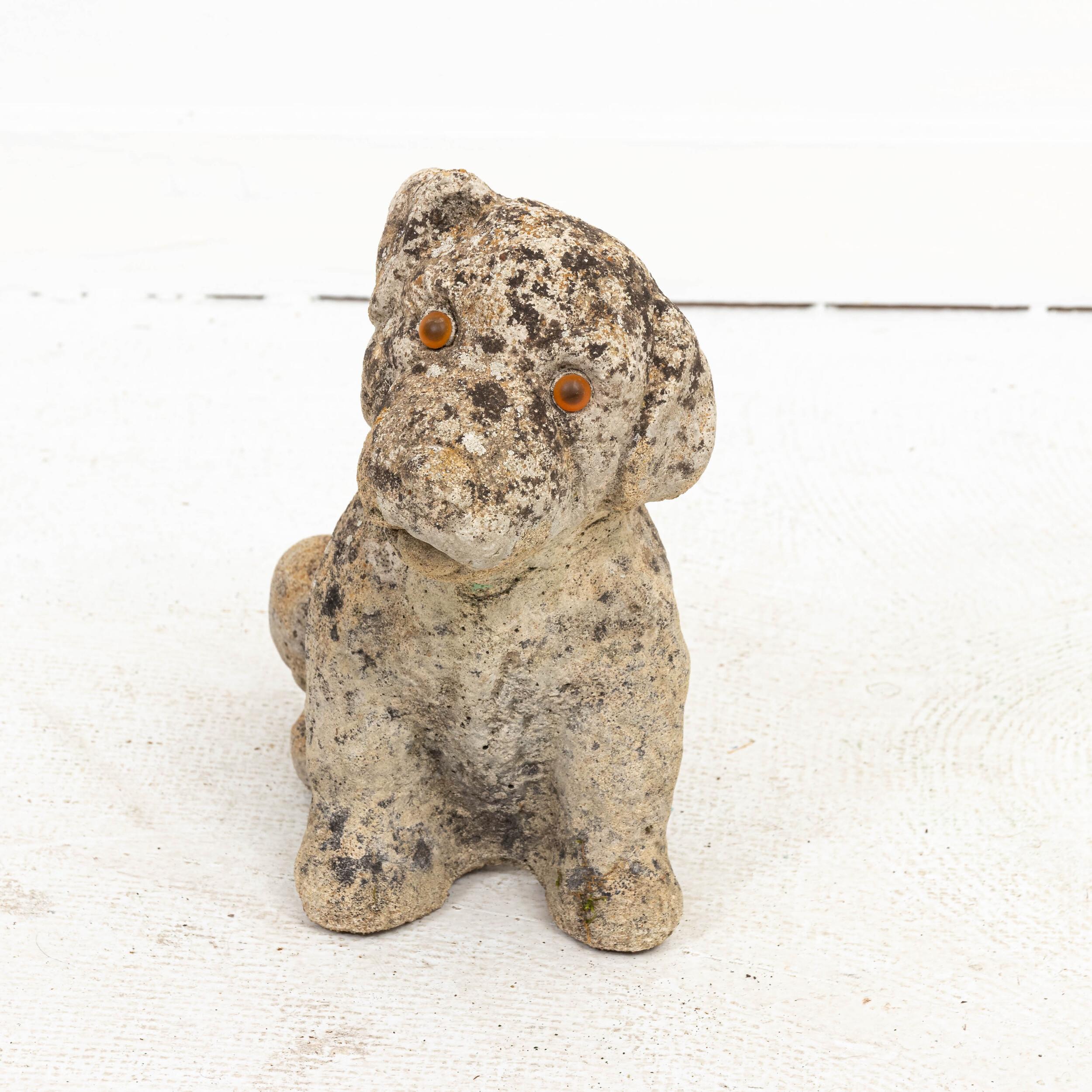 Unique cast stone garden statue of a puppy with striking amber eyes. Made in England circa early 1900s. Original garden patina with moss covering adds to its character.